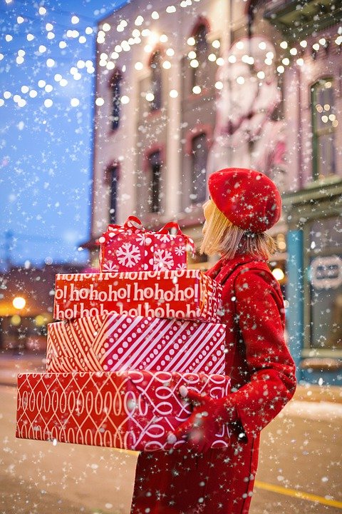 Mujer llevando varios regalos de Navidad en la calle. | Foto: Pixabay