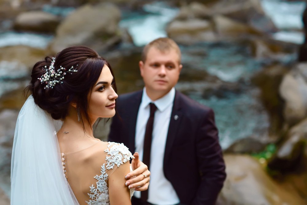 Bride and groom near waterfall | Image: Shutterstock