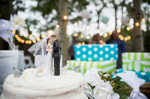Bride and groom cake topper on cake | Photo: Getty Images
