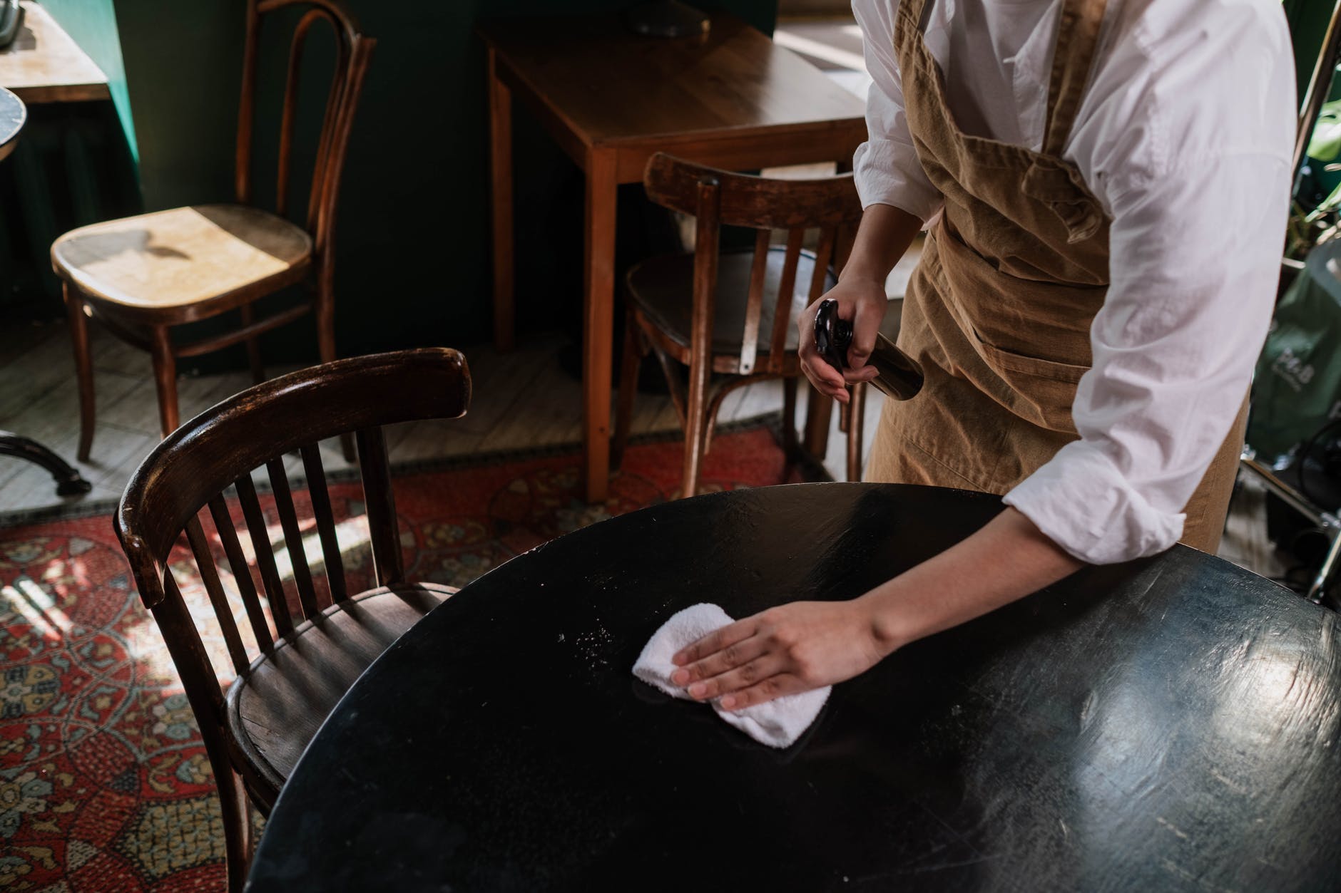 Una camarera limpia una de las meses a su cargo. | Foto: Pexels