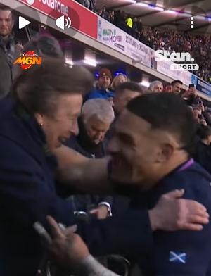 Princess Anne reacts swiftly yet gently, placing her arms outward as Sione Tuipulotu's celebratory momentum carries him forward, her smile suggesting composure rather than discomfort. The exchange, brief but unmistakable, unfolds as spectators in the stands watch the unexpected choreography between protocol and passion. | Source: YouTube/StanSportAU
