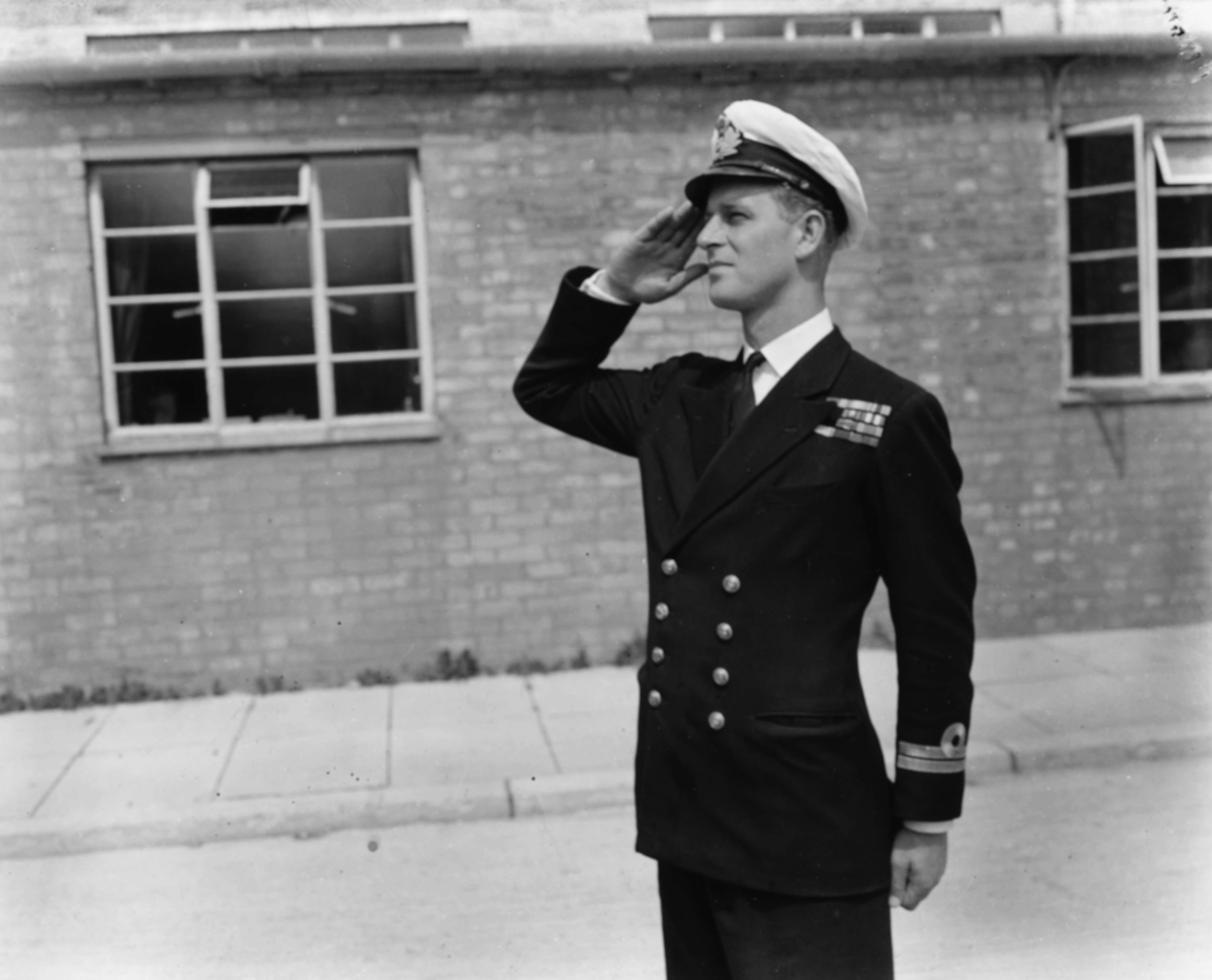Lieutenant Philip Mountbatten, prior to his marriage to Princess Elizabeth, saluting as he resumes his attendance at the Royal Naval Officers School at Kingsmoor, England, July 31, 1947. | Source: Getty Images