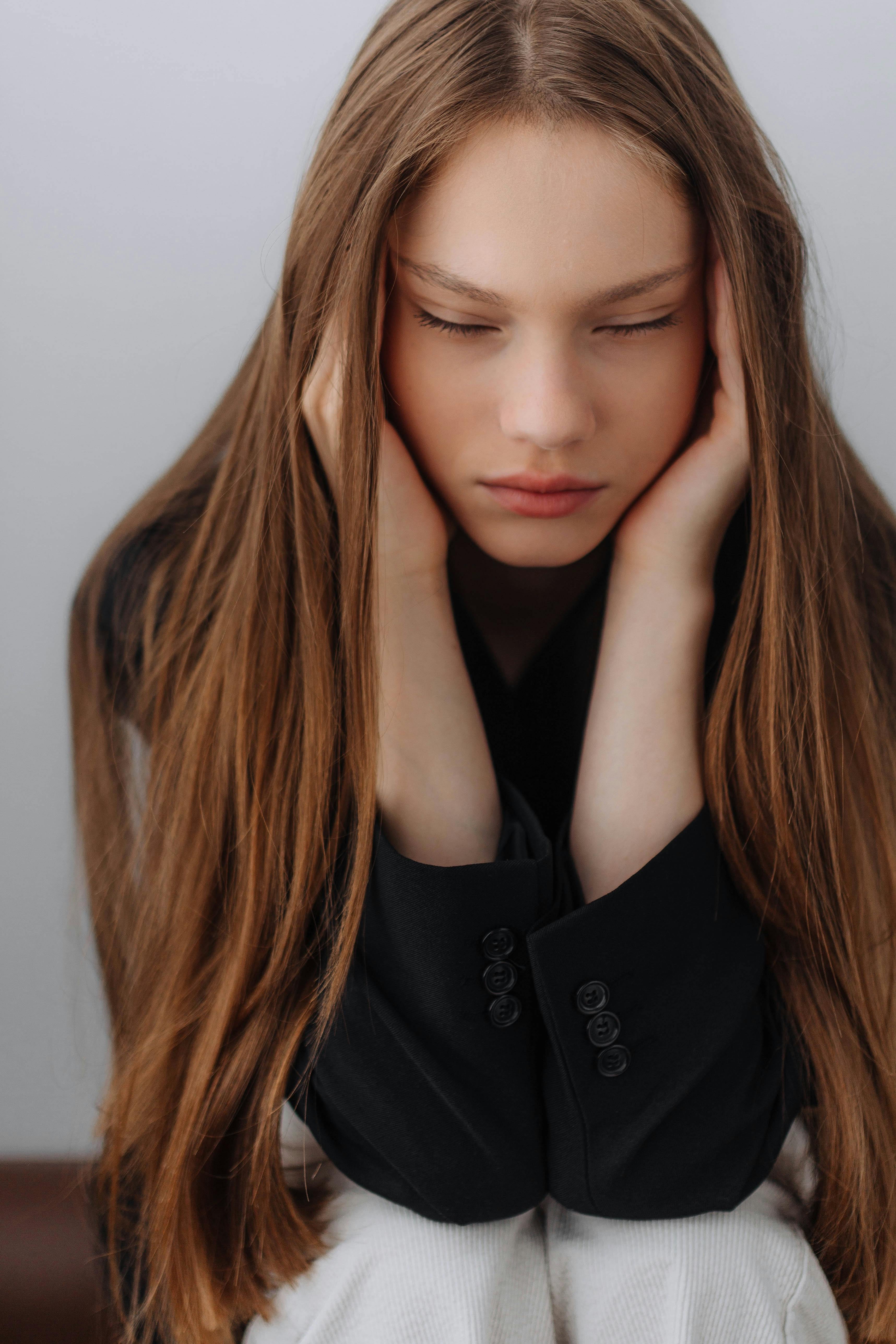 A young woman covering her ears | Source: Pexels