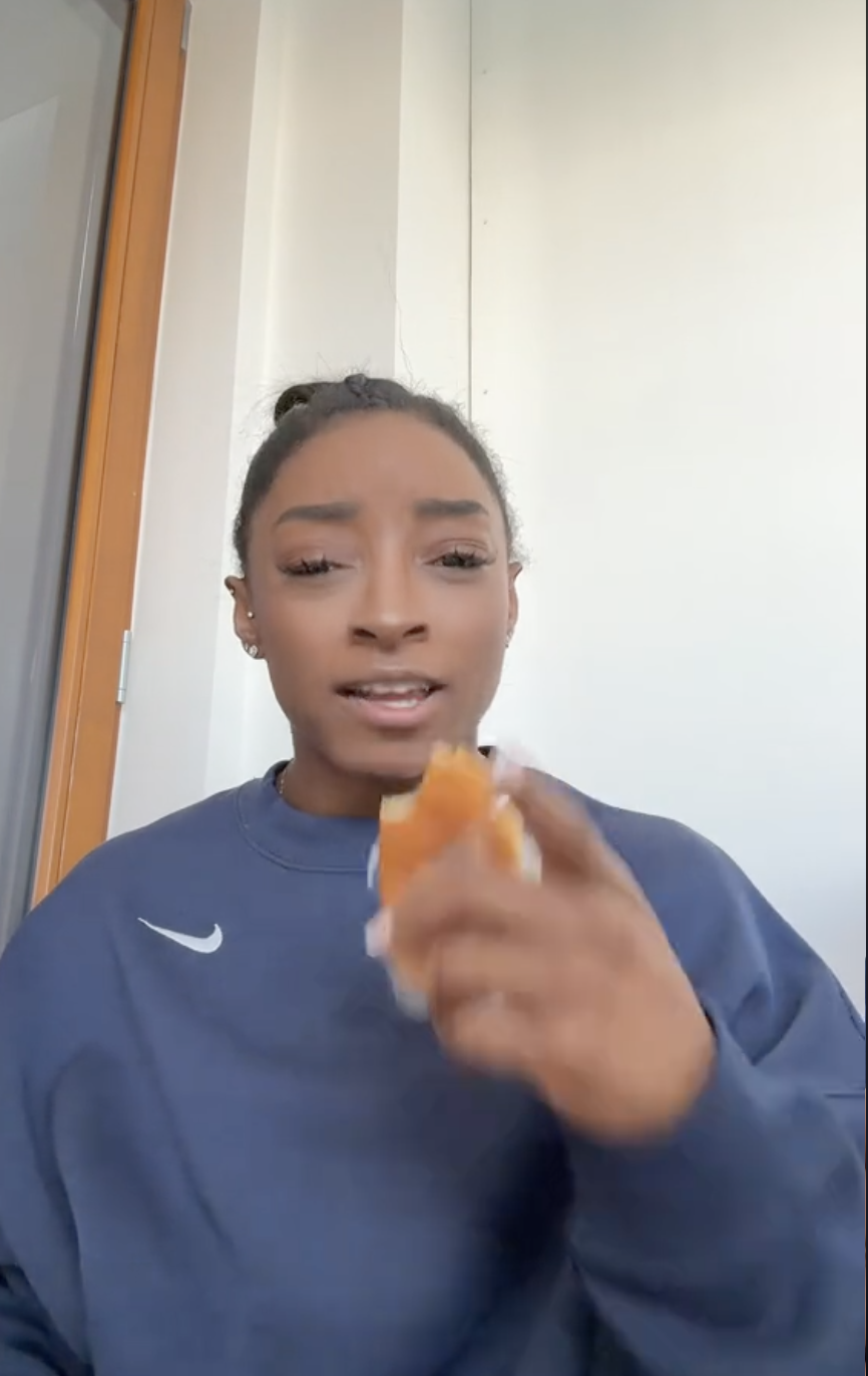 A screenshot of Simone BIles eating a croissant in her room at the Olympic Village | Source: TikTok/simonebilesowens