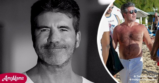 Simon Cowell flashes his belly on camera during a pre-Christmas day on the beach