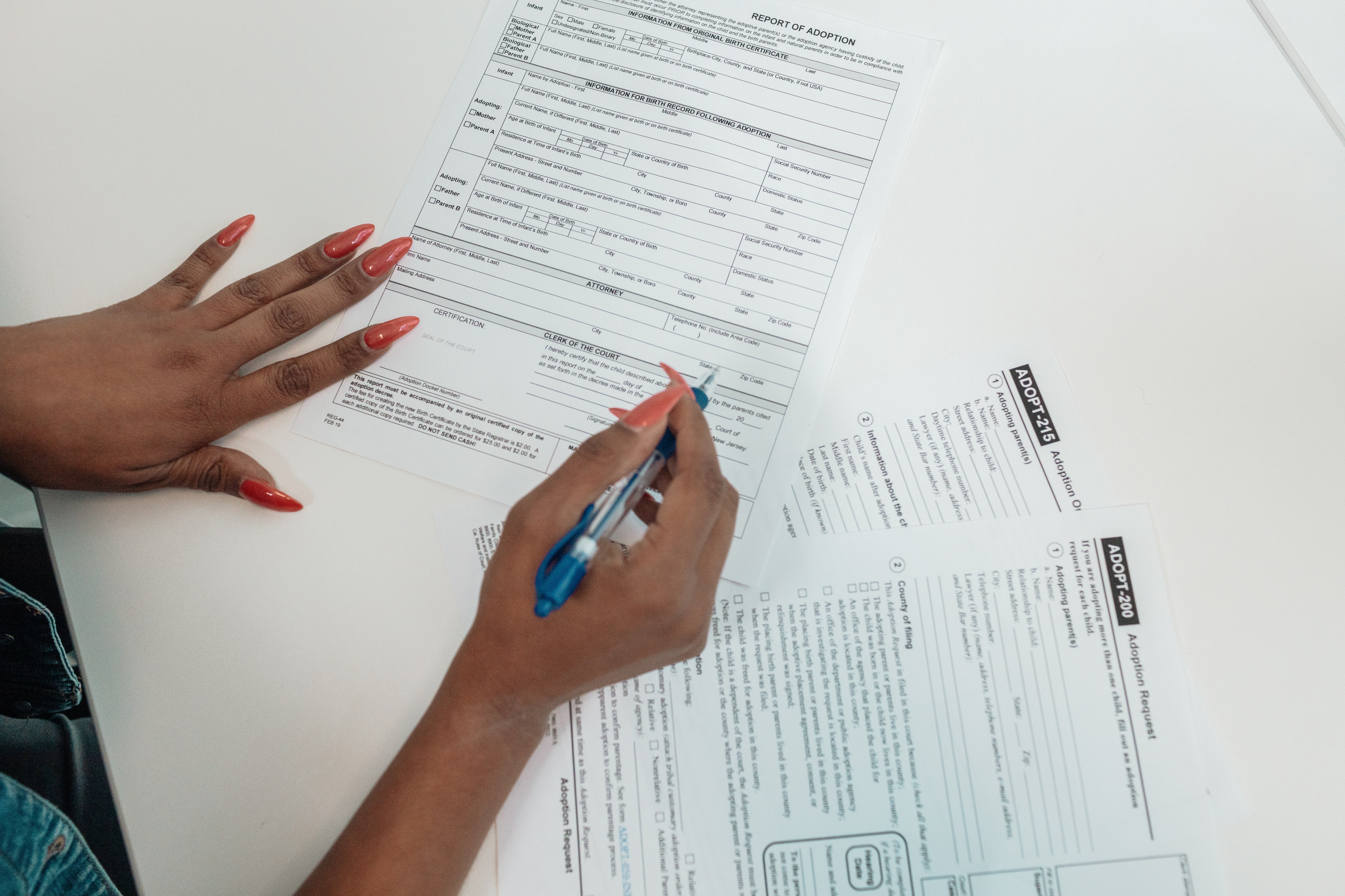 A woman can be seen filling in adoption forms | Pexels/Kindel Media 