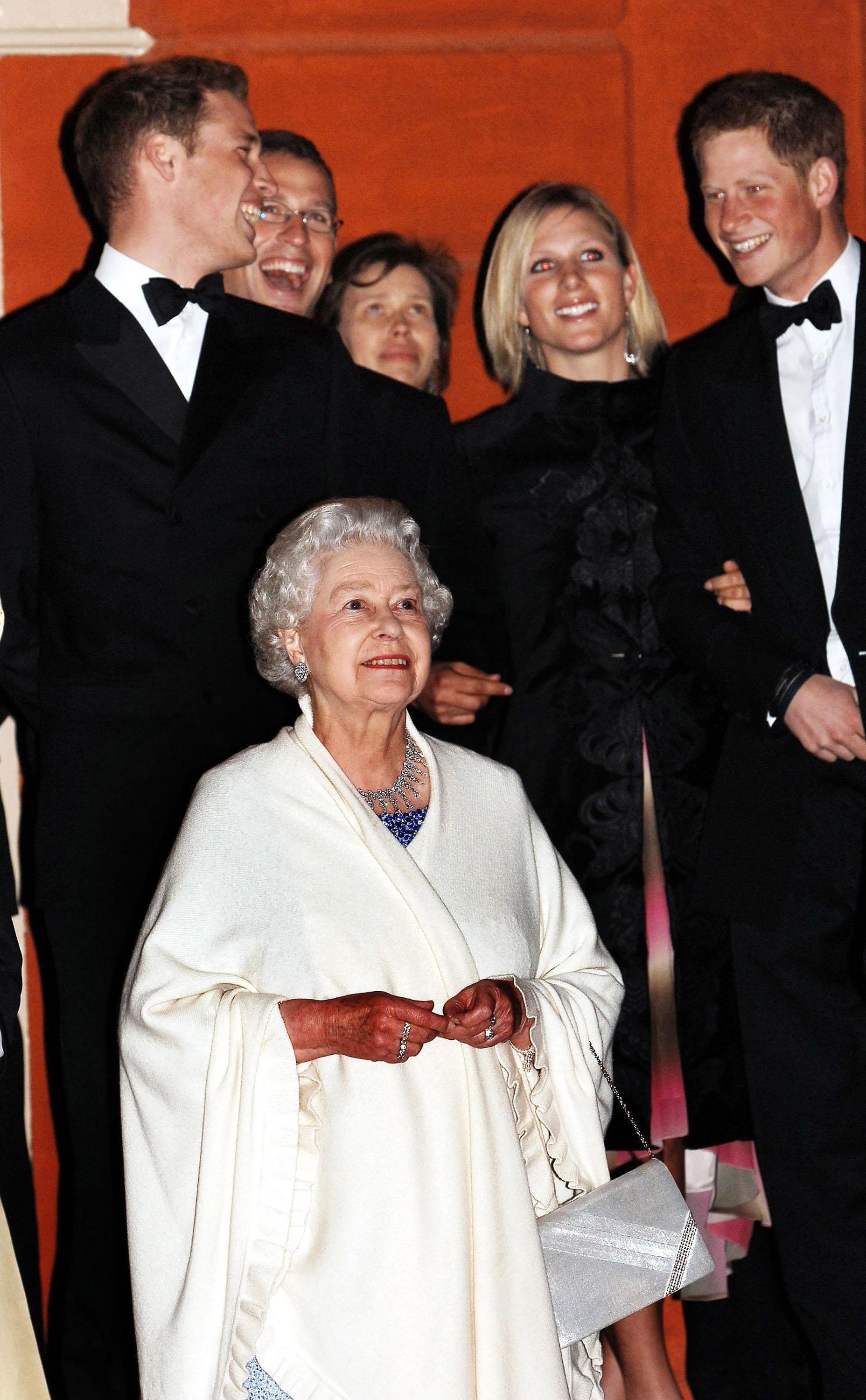 Königin Elizabeth ll. sieht sich ein Feuerwerk an, während vier ihrer Enkel, Prinz William, Peter Phillips, Zara Phillips und Prinz Harry, hinter ihr im Kew Palace im Westen Londons stehen, um den 80. Geburtstag der Königin am 21. April 2006 zu feiern | Quelle: Getty Images