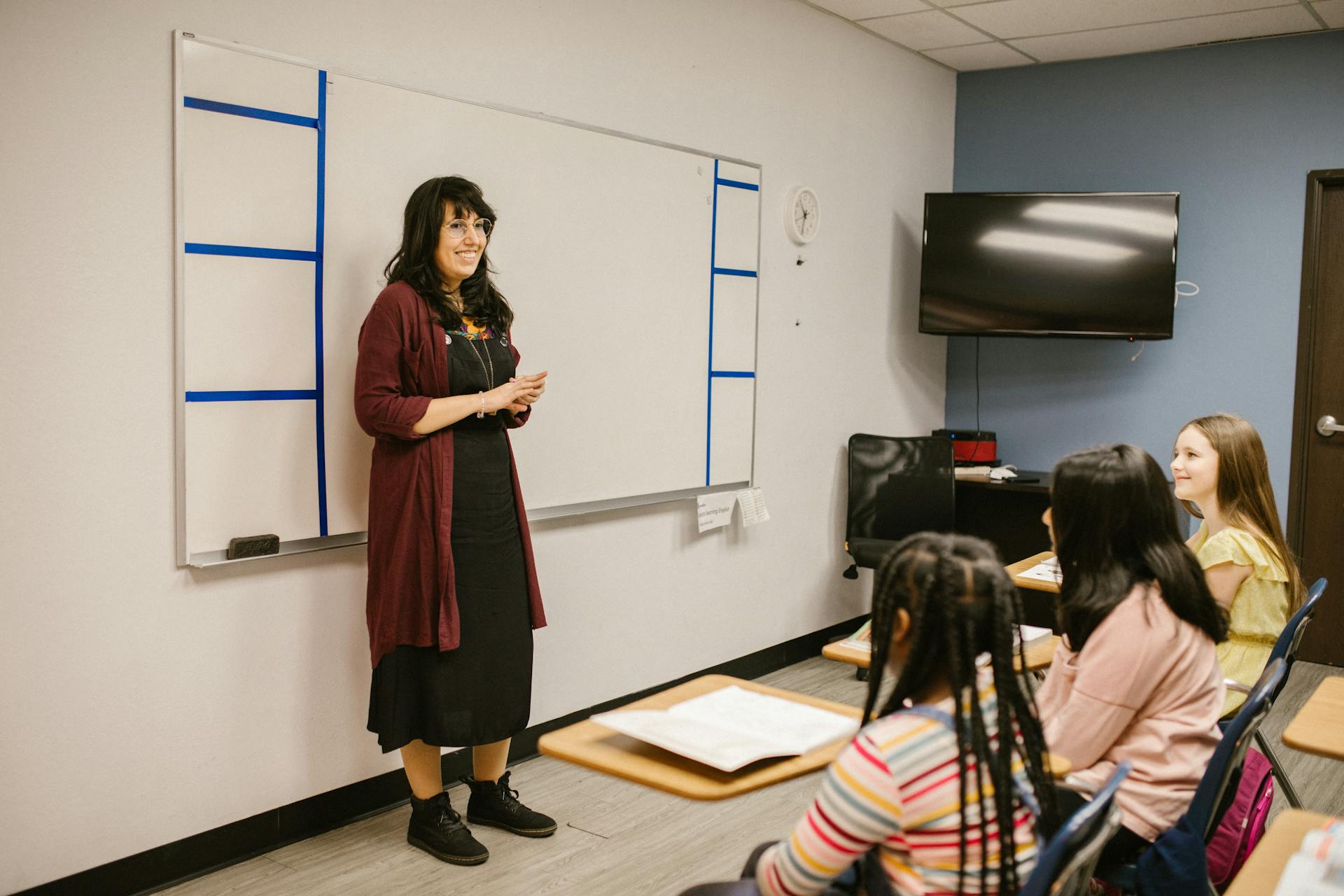 A smiling teacher discussing the lesson with her students | Source: Pexels