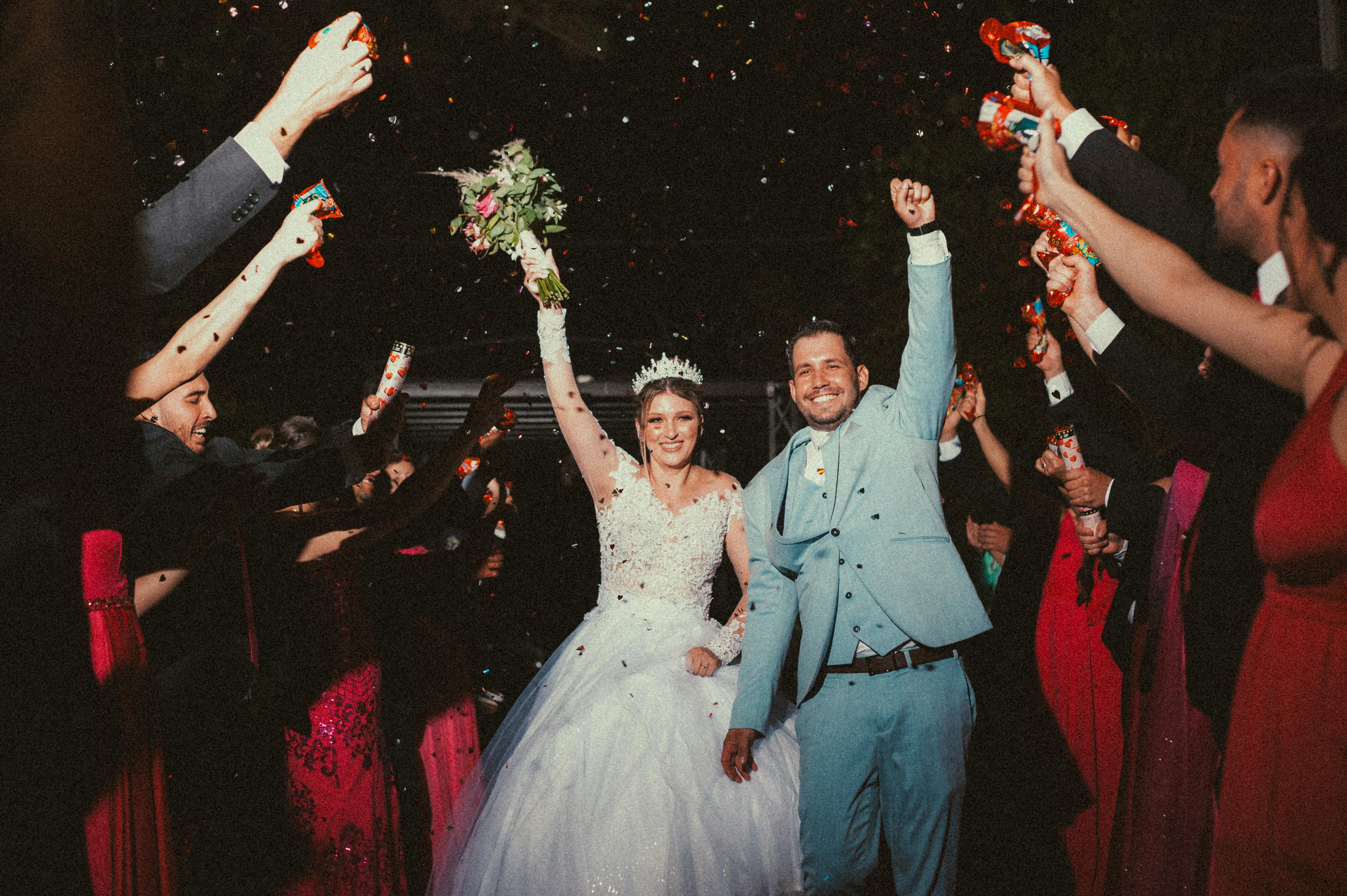 A married couple making through a tunnel of hands and confetti | Source: Pexels