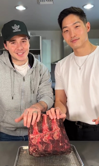 Brooklyn Beckham prepares a roast with chef Kevin Lee in a cooking video shared on January 4, 2023. | Source: Instagram/Brooklyn Peltz Beckham