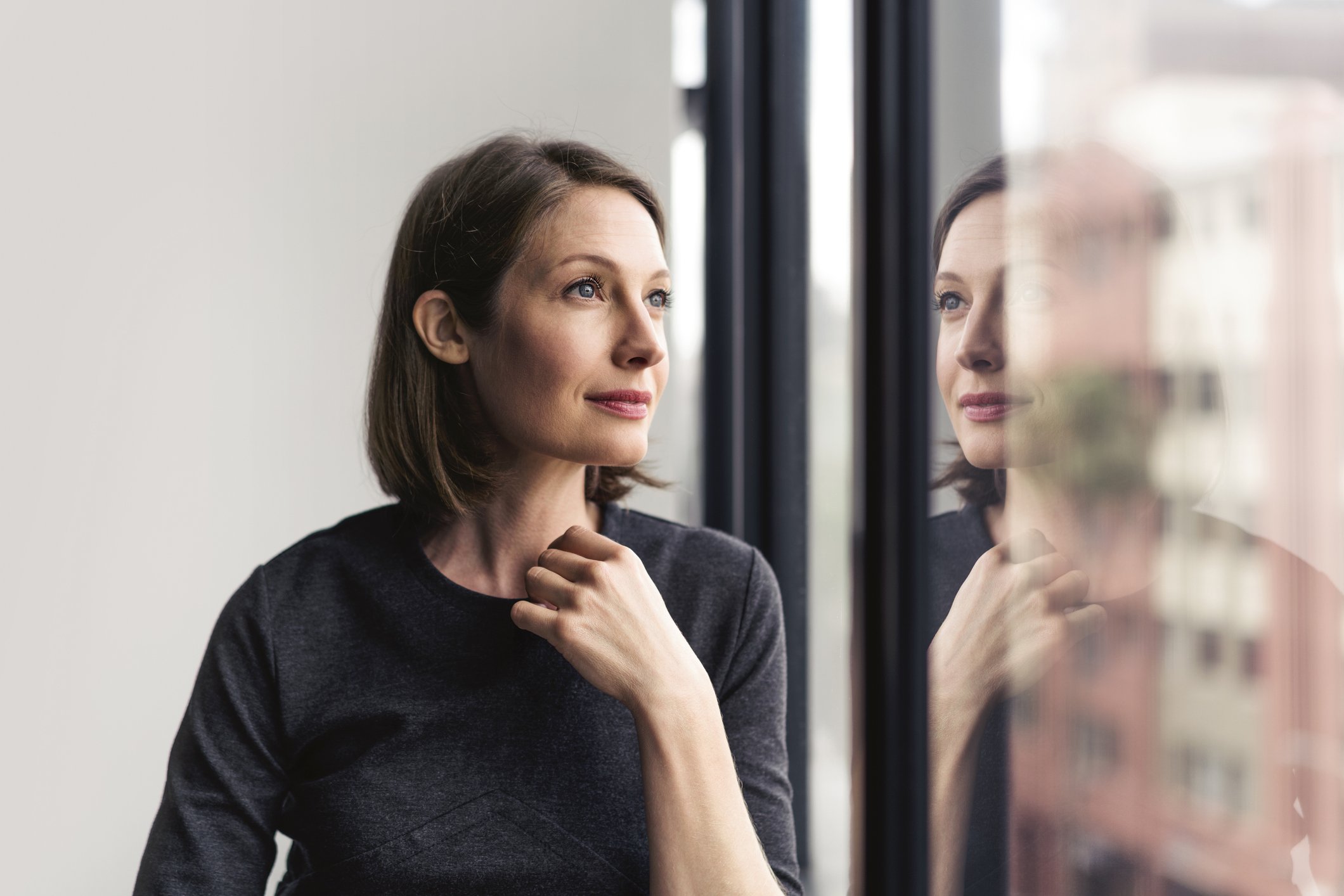 Une femme contemplant tristement par la fénêtre | source : Getty Images