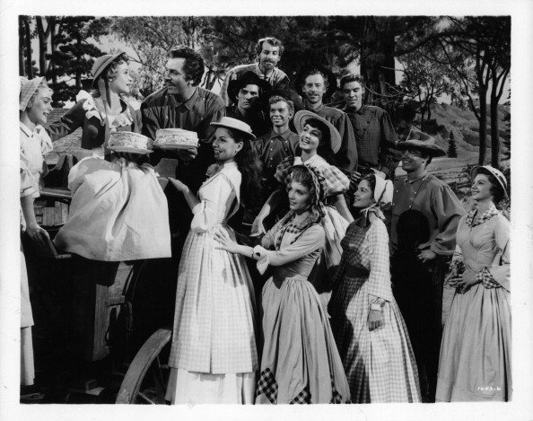 Nancey Kilgas, Jane Powell, Betty Carr, Ruta Kilmonis, Julie Newmeyer, Virginia Gibson and Norma Doggett as the seven brides and Howard Keel, Tommy Rall, Matt Mattox, Russ Tamblyn, Marc Platt, Jacques d Amboise and Jeff Richards as the seven brothers in a scene from the film 'Seven Brides For Seven Brothers', 1954 | Photo: Getty Images