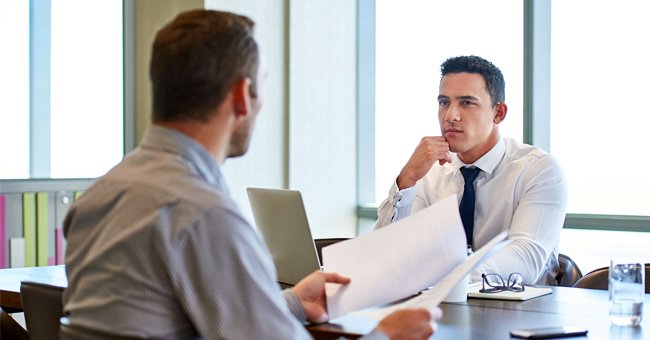 Photo of two men having a conversation in an office | Photo: Shutterstock.com