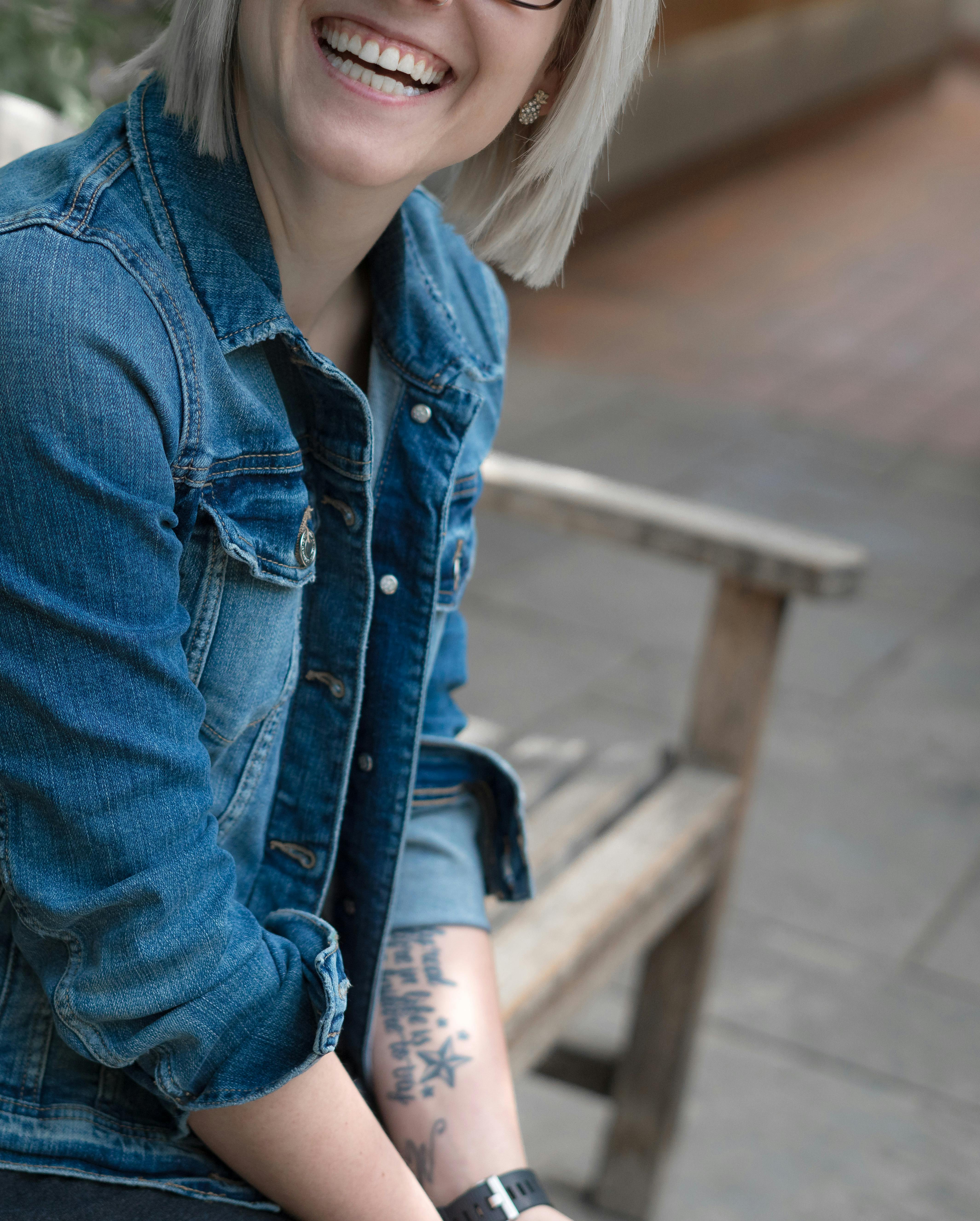 A woman smiling while wearing a denim jacket | Source: Pexels