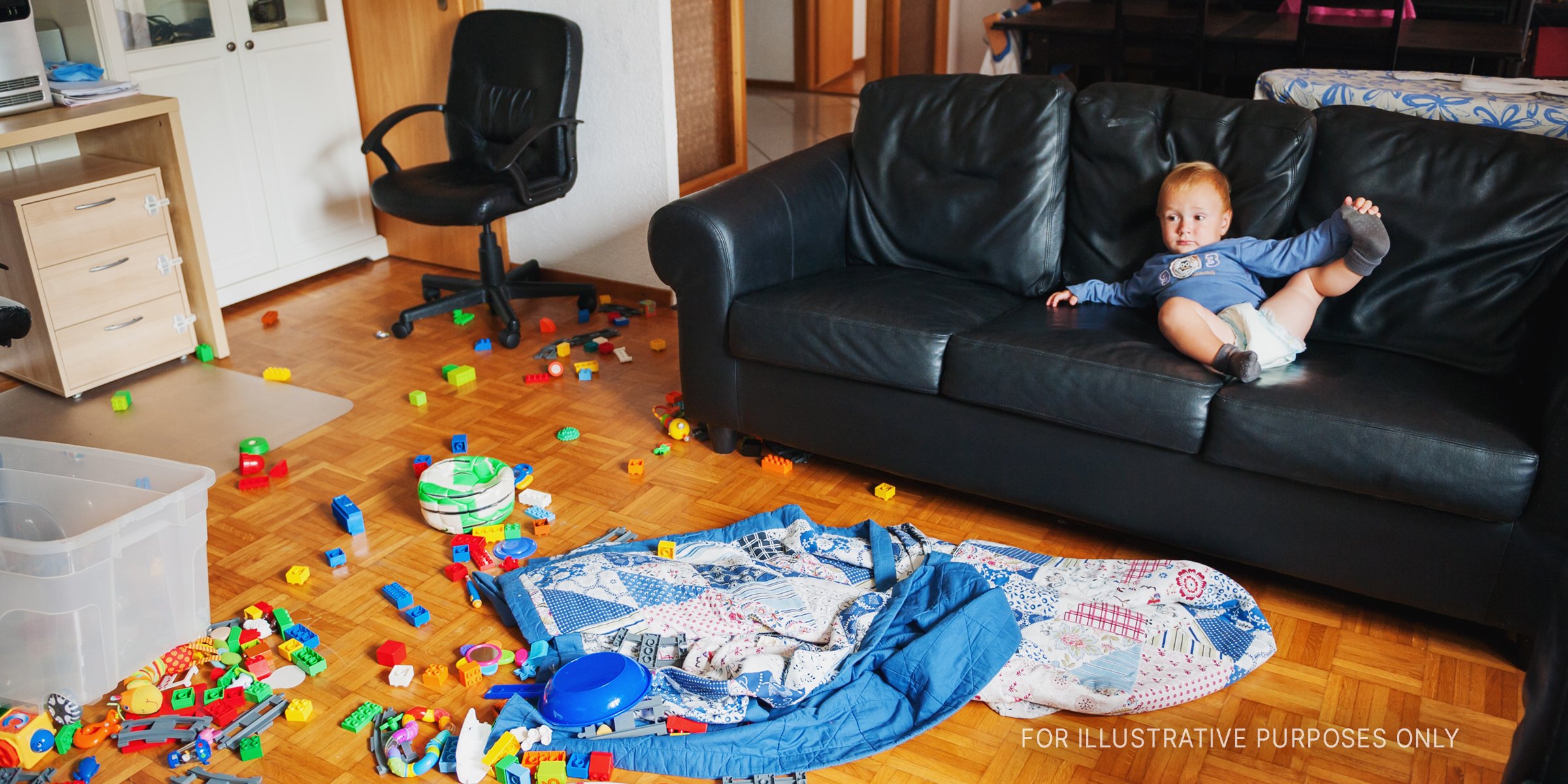 Baby lies on a couch in a messy room | Source: Shutterstock