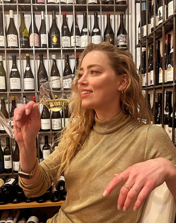 A photo of Amber Heard celebrating her 38th birthday with a glass of champagne, dated April 2024. | Source: Instagram/amberheard