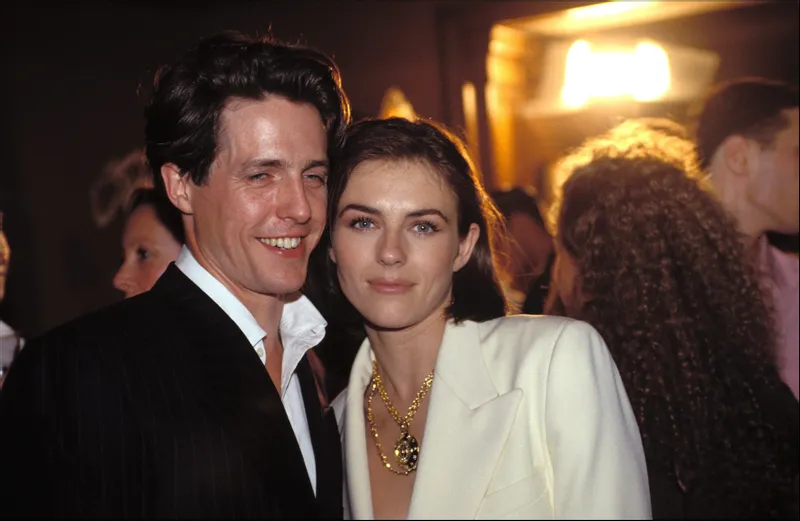 Hugh Grant and Elizabeth Hurley at the Gianni Versace Fashion Show in 1994 in Paris, France | Source: Getty Images