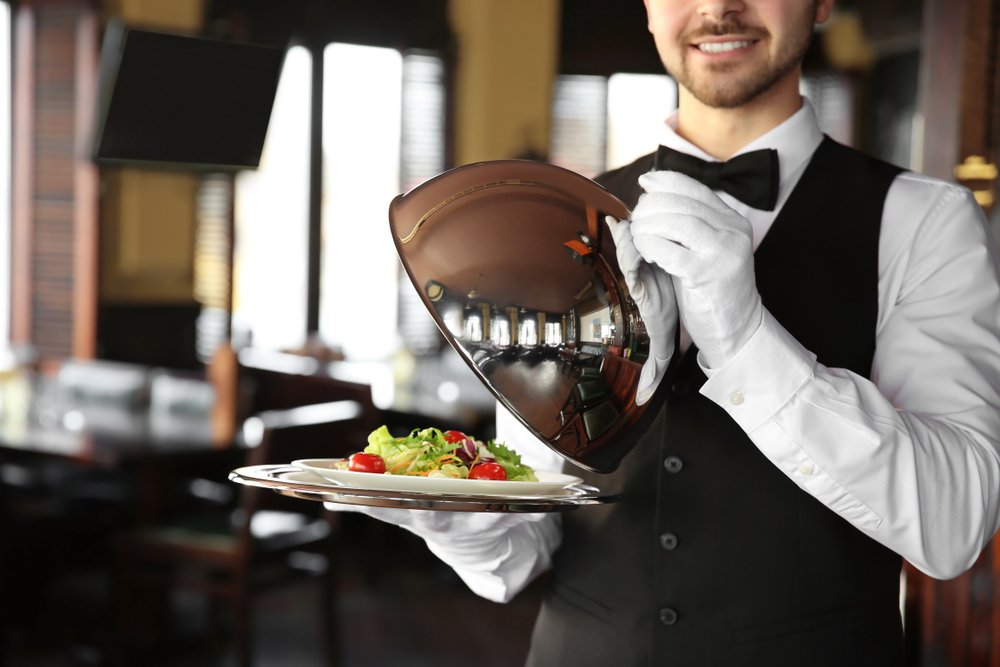 Camarero sosteniendo una bandeja con ensalada en su mano. | Foto: Shutterstock