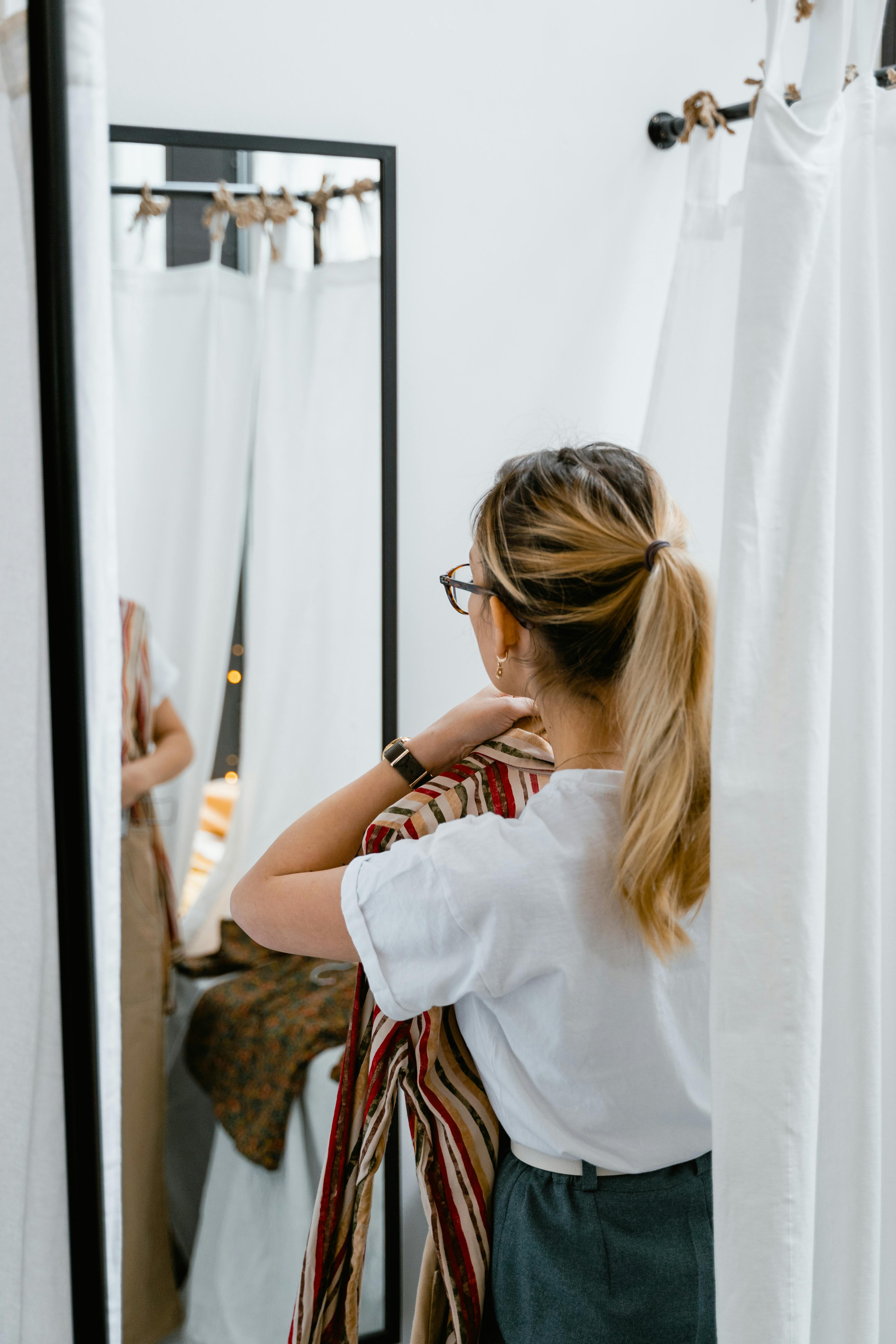 A woman holding clothes in the changing room | Source: Pexels