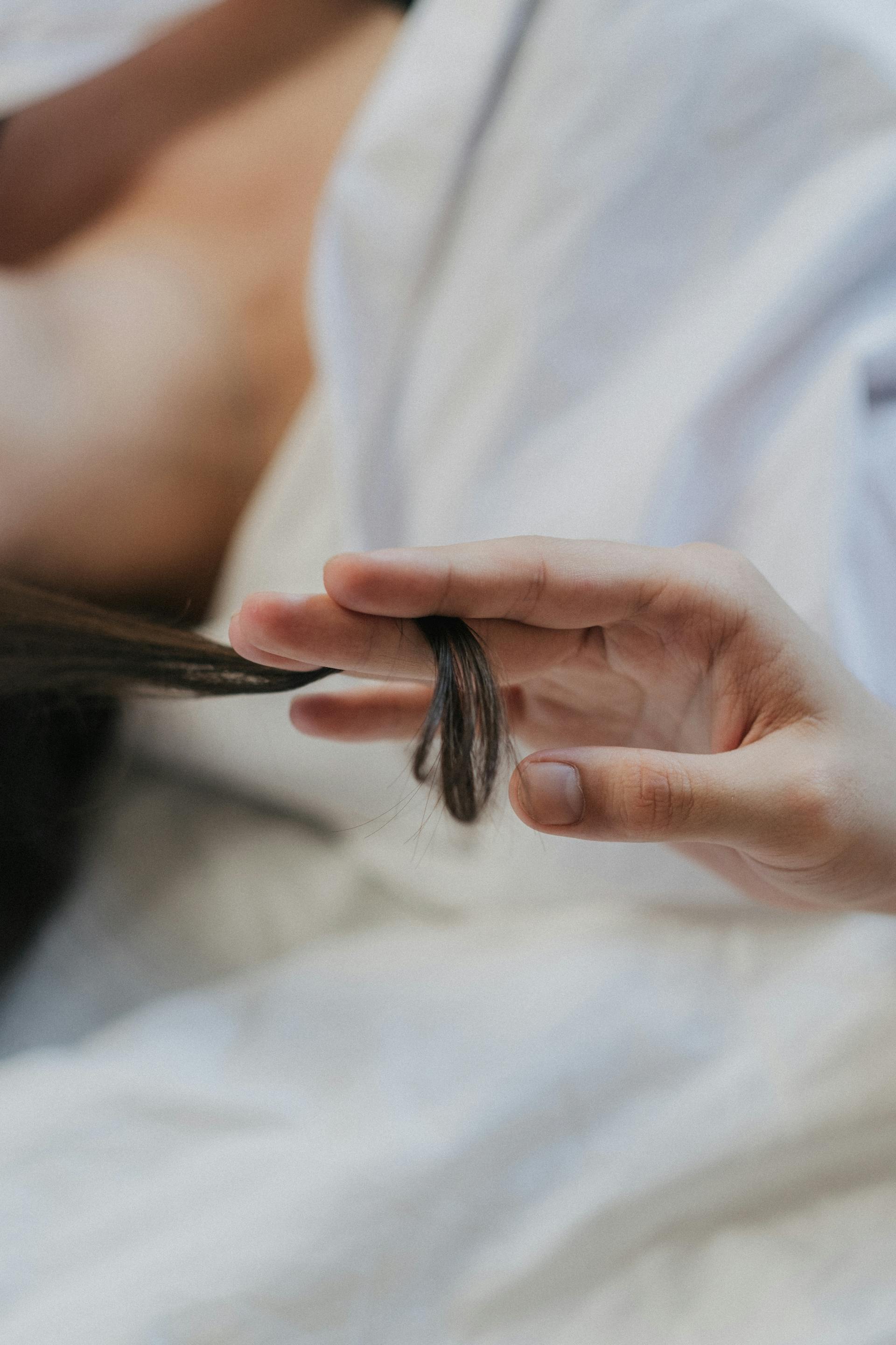 A person twirling a lock of hair | Source: Pexels