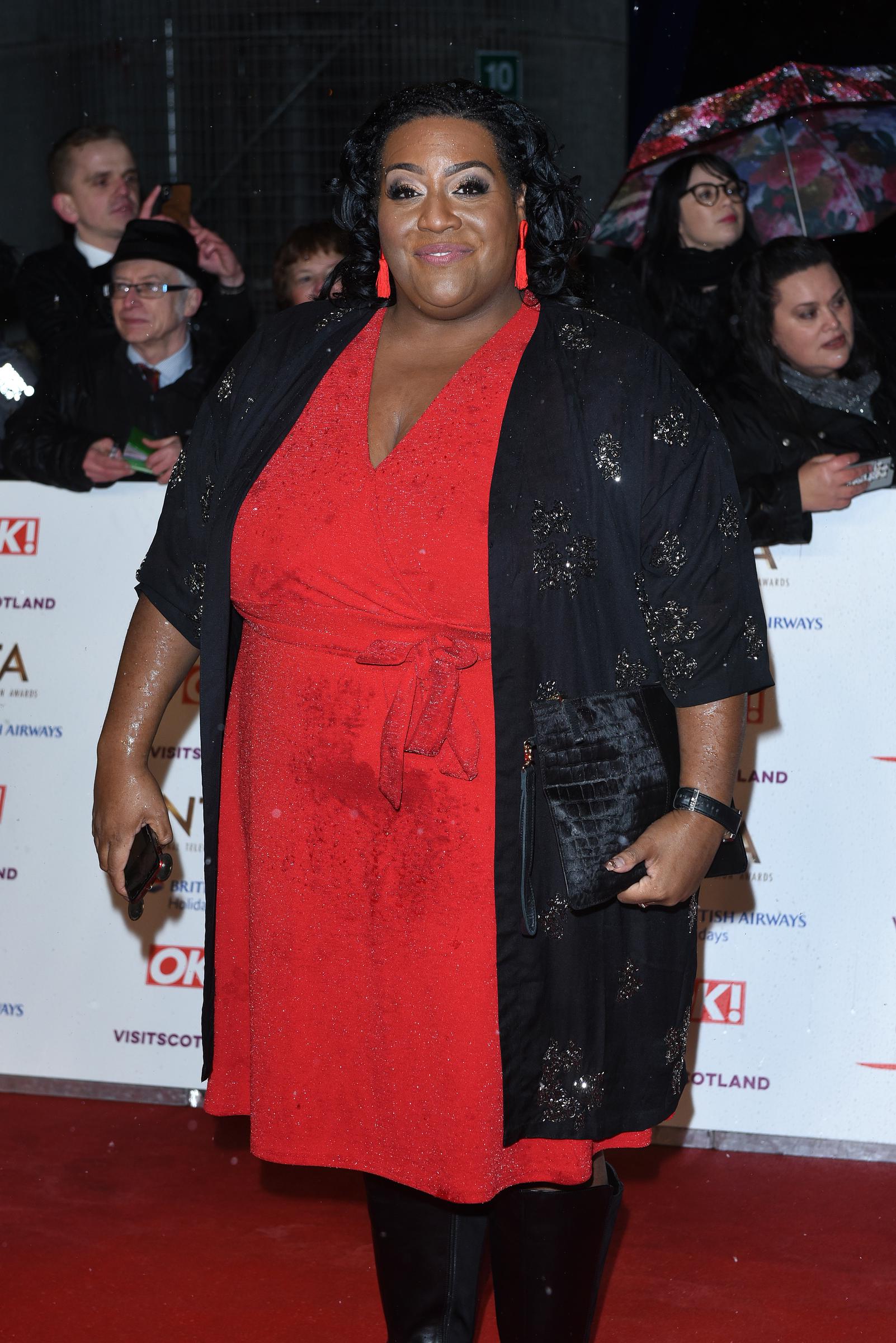 Undeterred by the rain, Hammond arrives smiling at the National Television Awards at The O2, London, on 22 January 2019. She stuns in a red wrap dress and black embellished coat, paired with knee-high boots and tassel earrings, as fans with umbrellas line the carpet behind her.