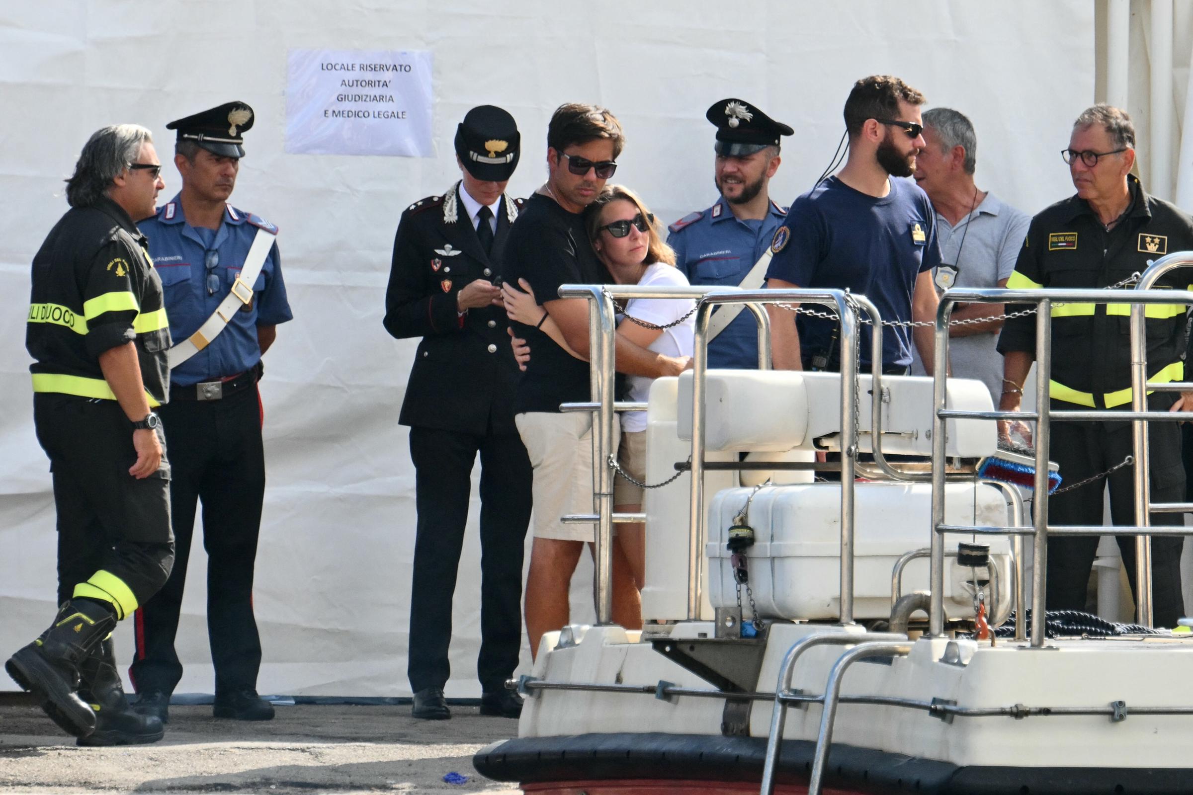 People hugging as they watched a search and rescue team operate on the pier of Porticello, Italy, on August 22, 2024, three days after the British-flagged luxury yacht Bayesian sank. | Source: Getty Images