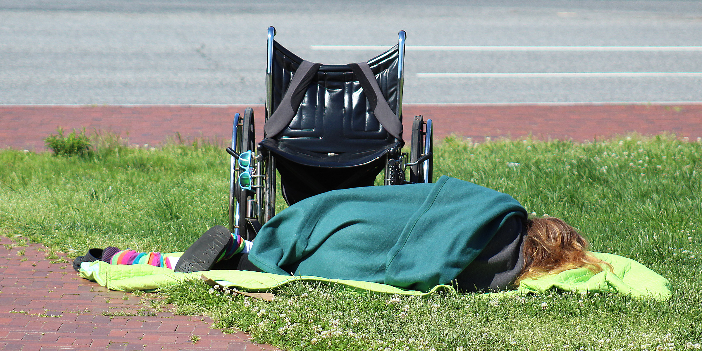 A homeless person sleeping on the ground | Source: Flickr