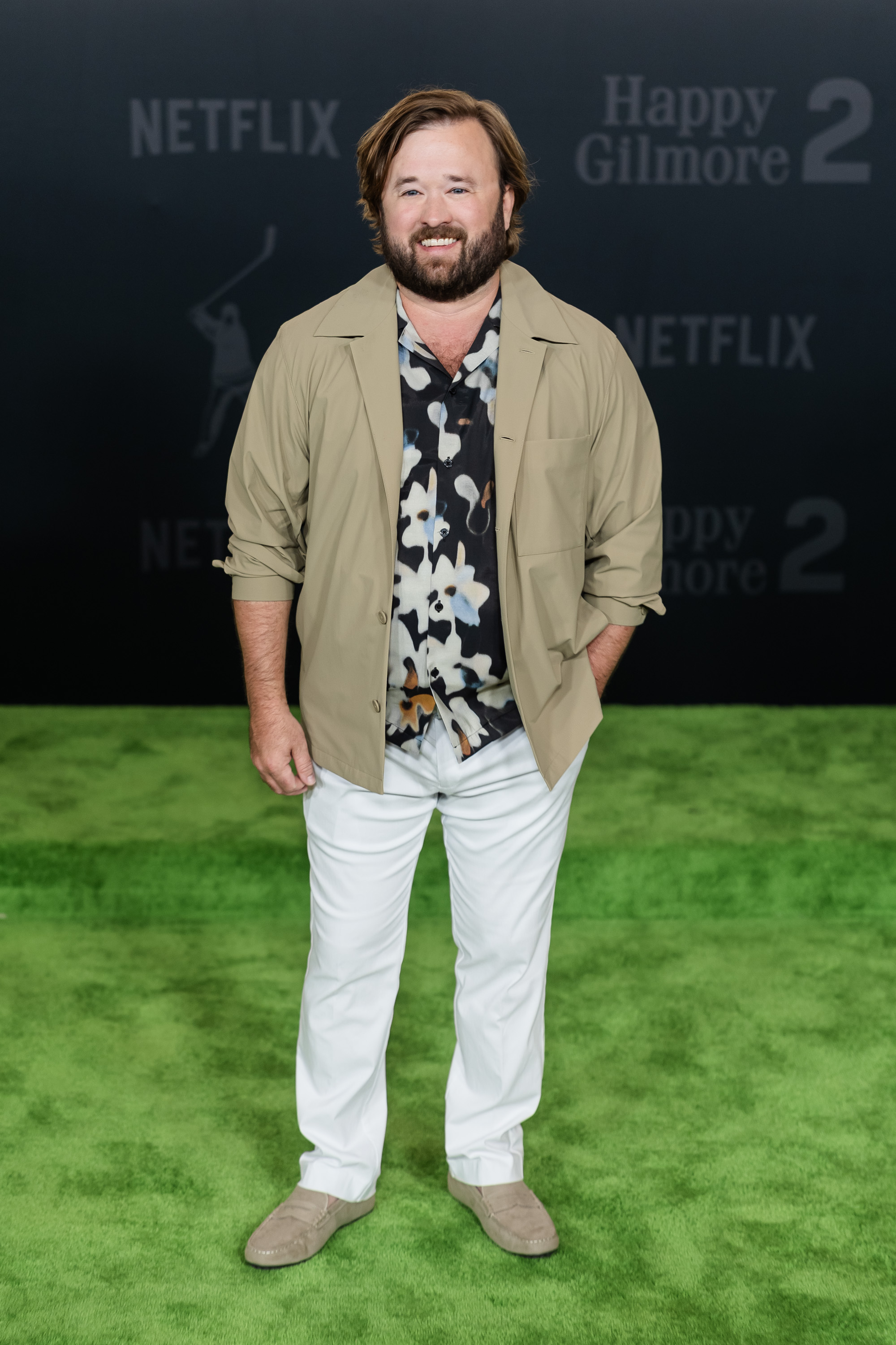 By 2025, Osment had fully embraced a low-key Hollywood presence, stepping onto the green carpet in white trousers, a floral shirt, and an open tan jacket. With a full beard and long hair, the former child star had traded intense drama for quirky roles and indie comedies — and looked totally at ease doing so.