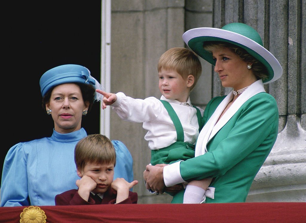 Princess Diana holds Prince Harry in her arms as they stand with Prince William and Princess Margaret from the balcony at Buckingham Palace for the Trooping The Colour on June 11, 1988, England | Source: Tim Graham Photo Library via Getty Images