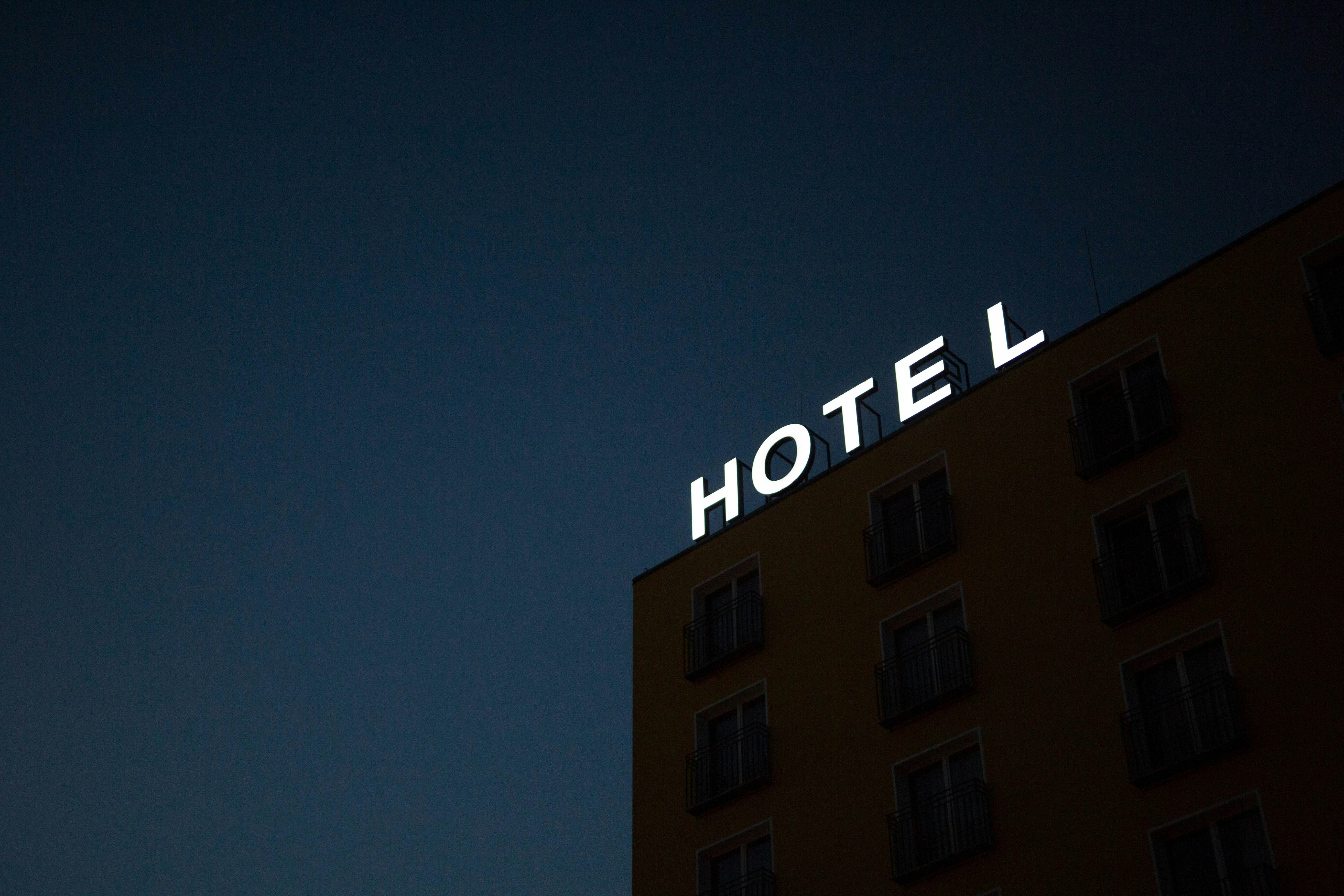 A neon sign reading "HOTEL" at the top of a building | Source: Unsplash