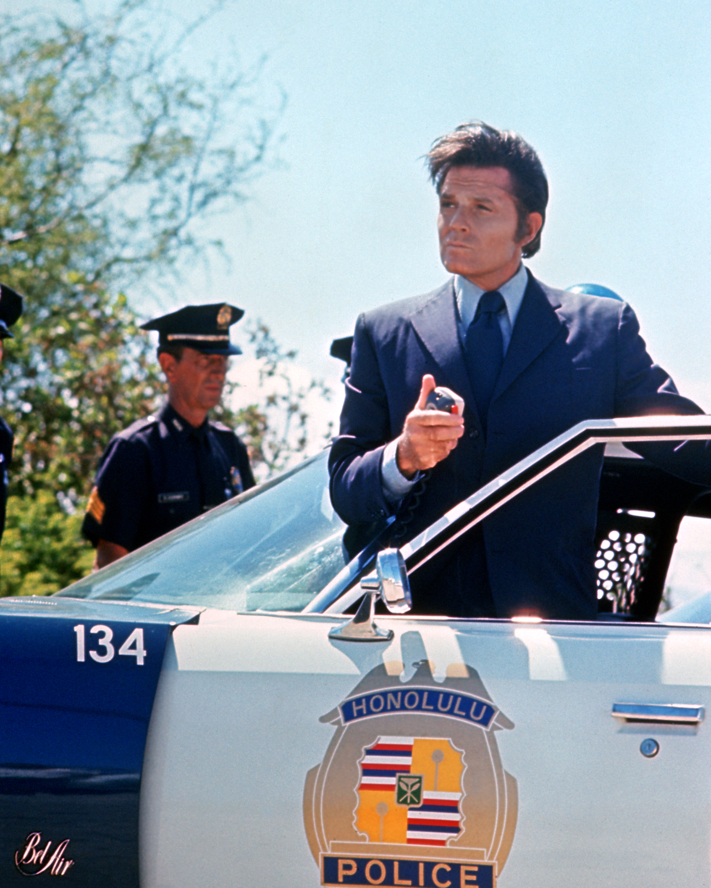 Jack Lord stands in the open door of a police car in a publicity image issued for the US television series, 'Hawaii Five-0', USA, circa 1975. | Source: Getty Images