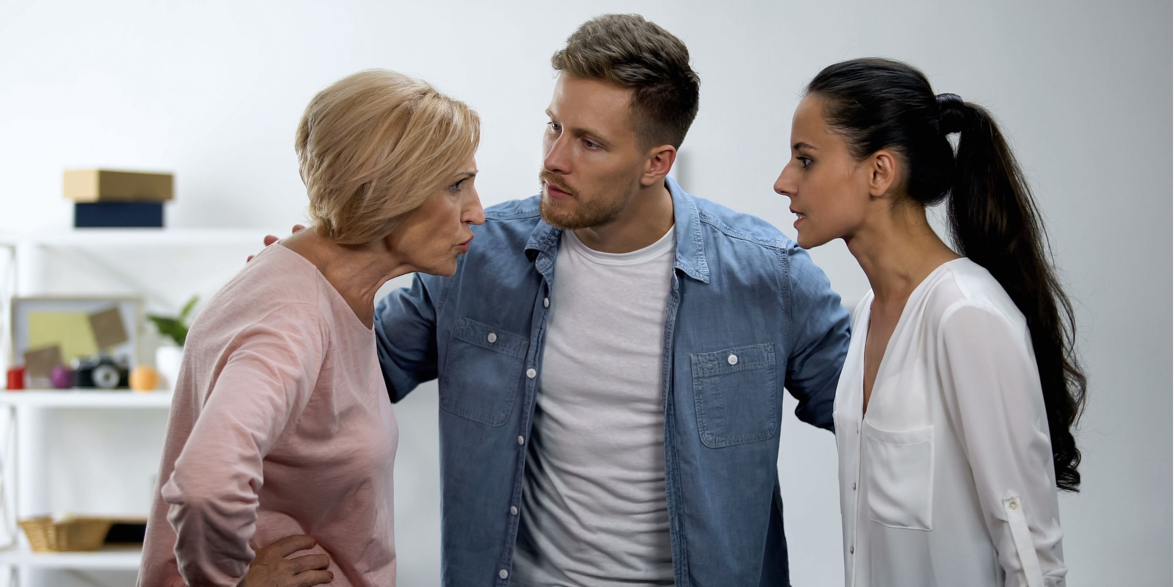 A man standing between his mother and wife | Source: Shutterstock