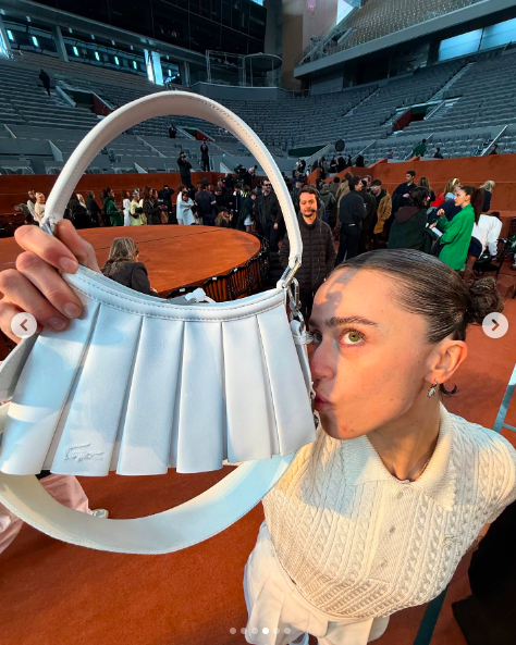 Ella Emhoff kissing her white handbag. | Source: Instagram/ellaemhoff