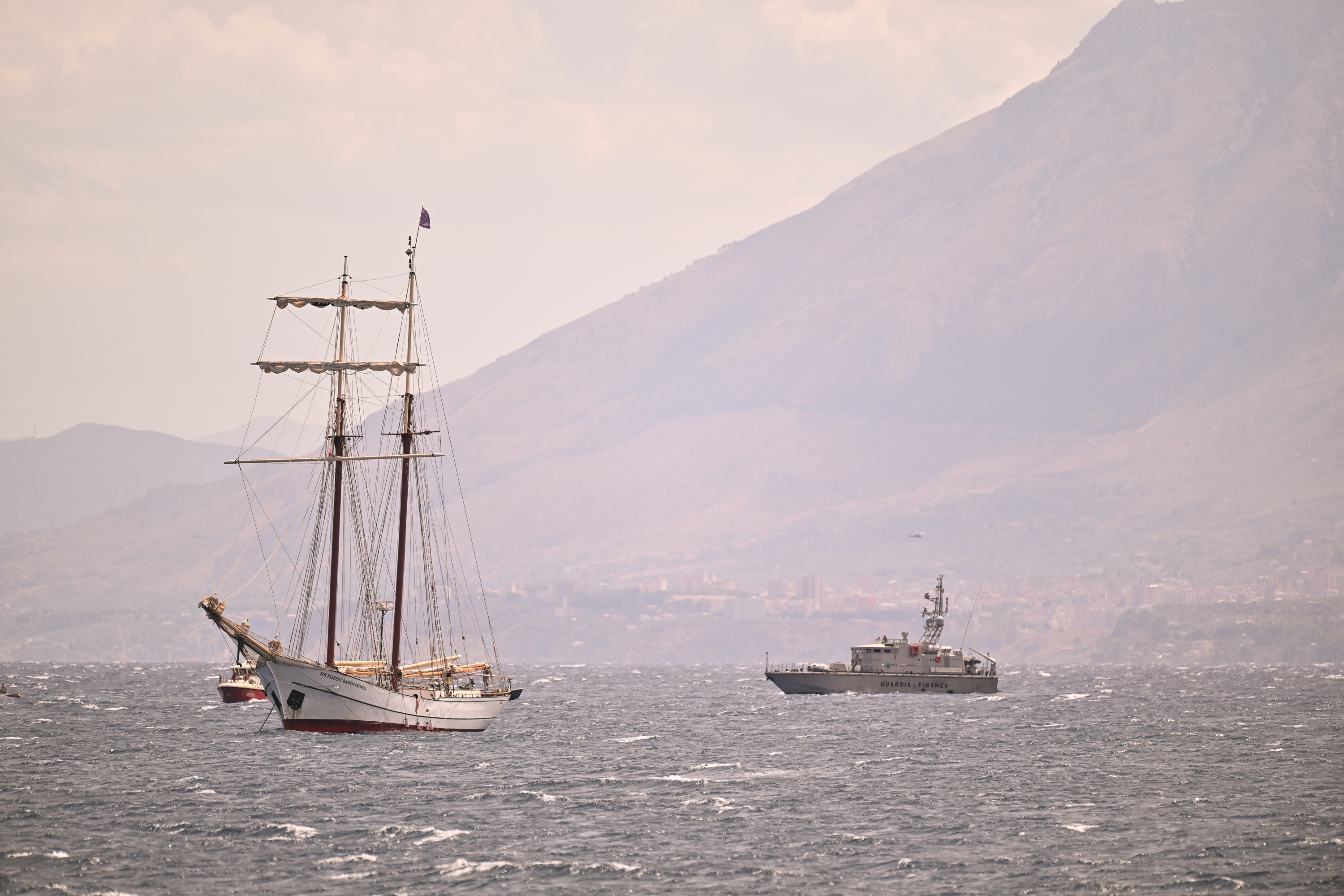 A coast guard vessel and a private sail boat assist the search for missing passengers in Porticello, Italy on August 19, 2024 | Source: Getty Images