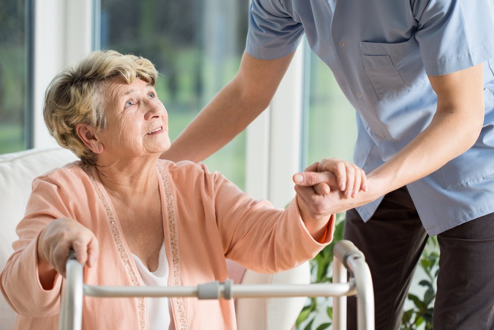 A photo of an elderly woman helped by a nurse. | Photo: Shutterstock.