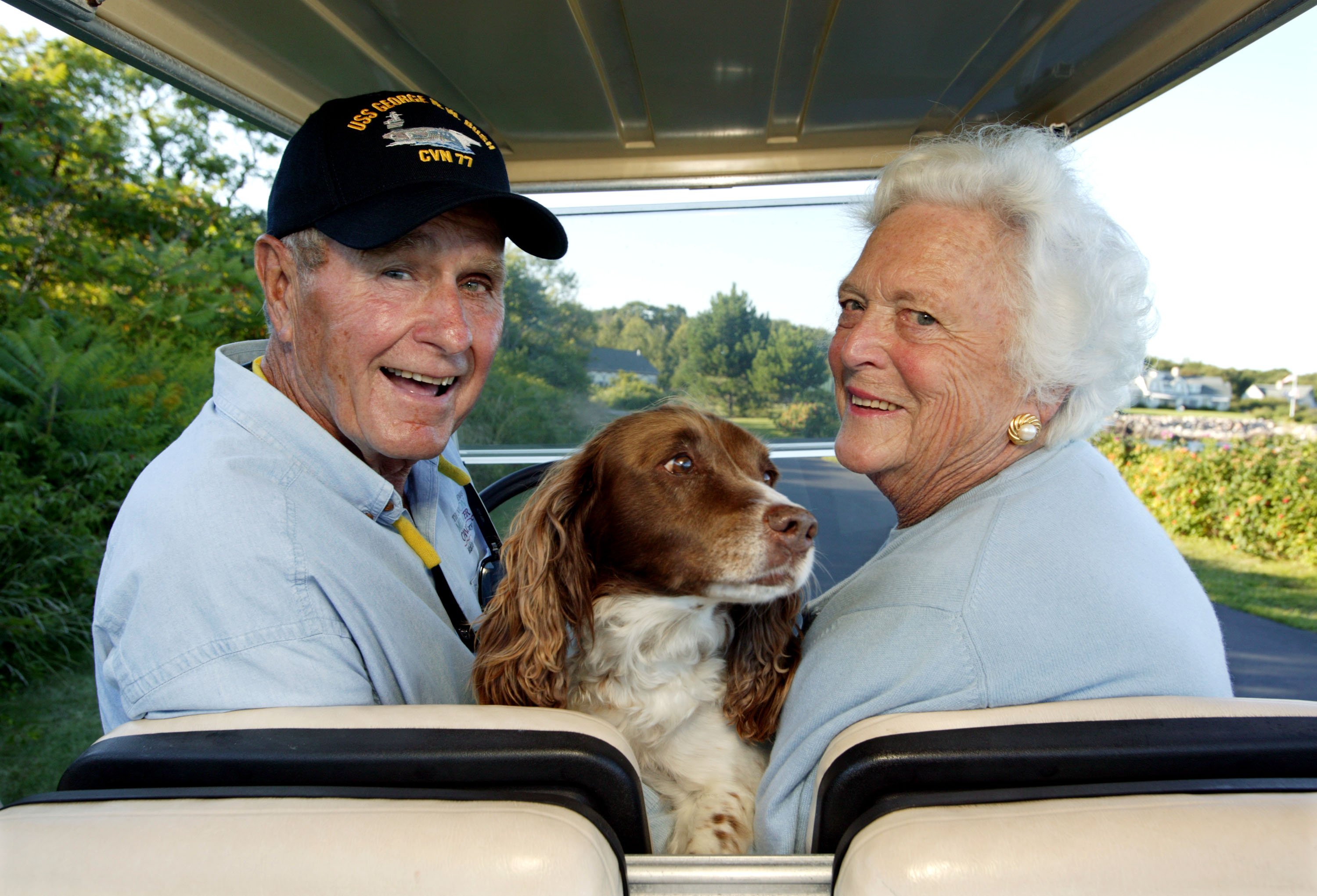 L'ancien président américain George H. W. Bush et son épouse, Barbara Bush, se promènent à l'arrière d'une voiturette de golf avec leur chien Millie dans leur maison de Walker's Point, le 25 août 2004 à Kennebunkport, dans le Maine : Getty Images