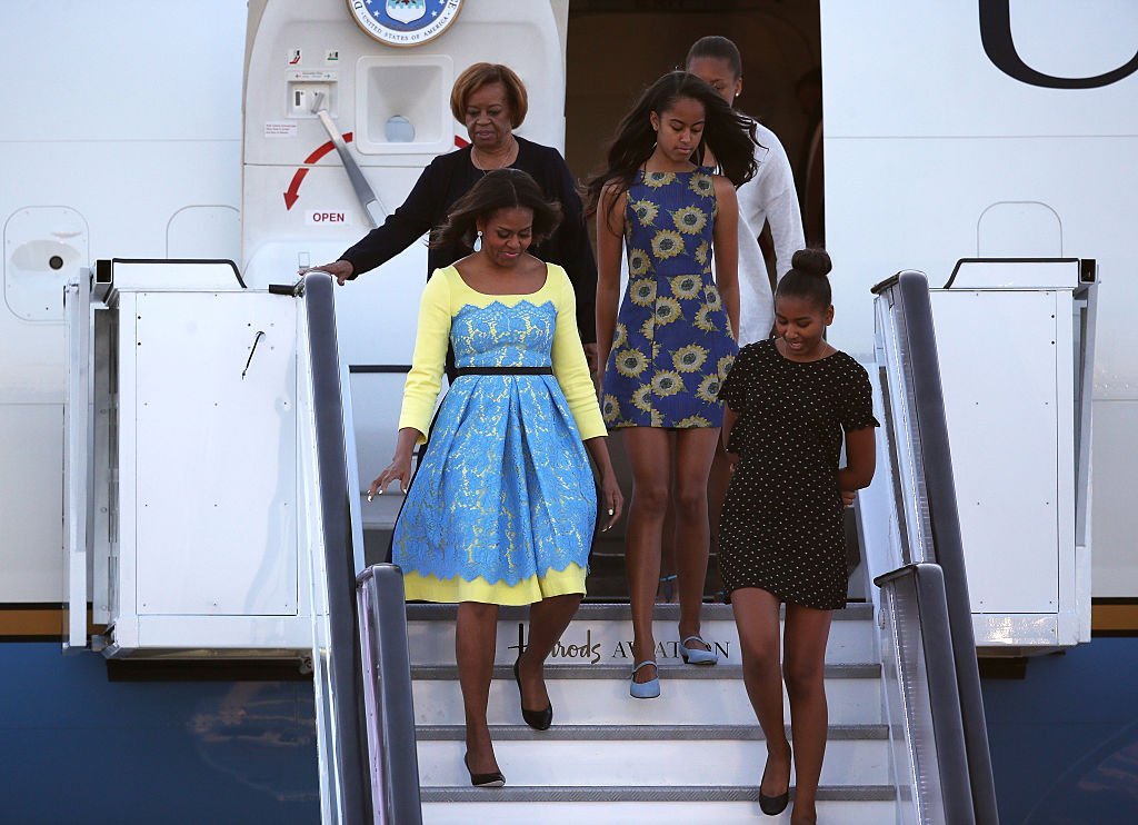 Then First Lady Michelle Obama arriving at Stanstead airport in London with daughters Malia and Sasha Obama and her mother, Marian Robinson on June 15, 2015.