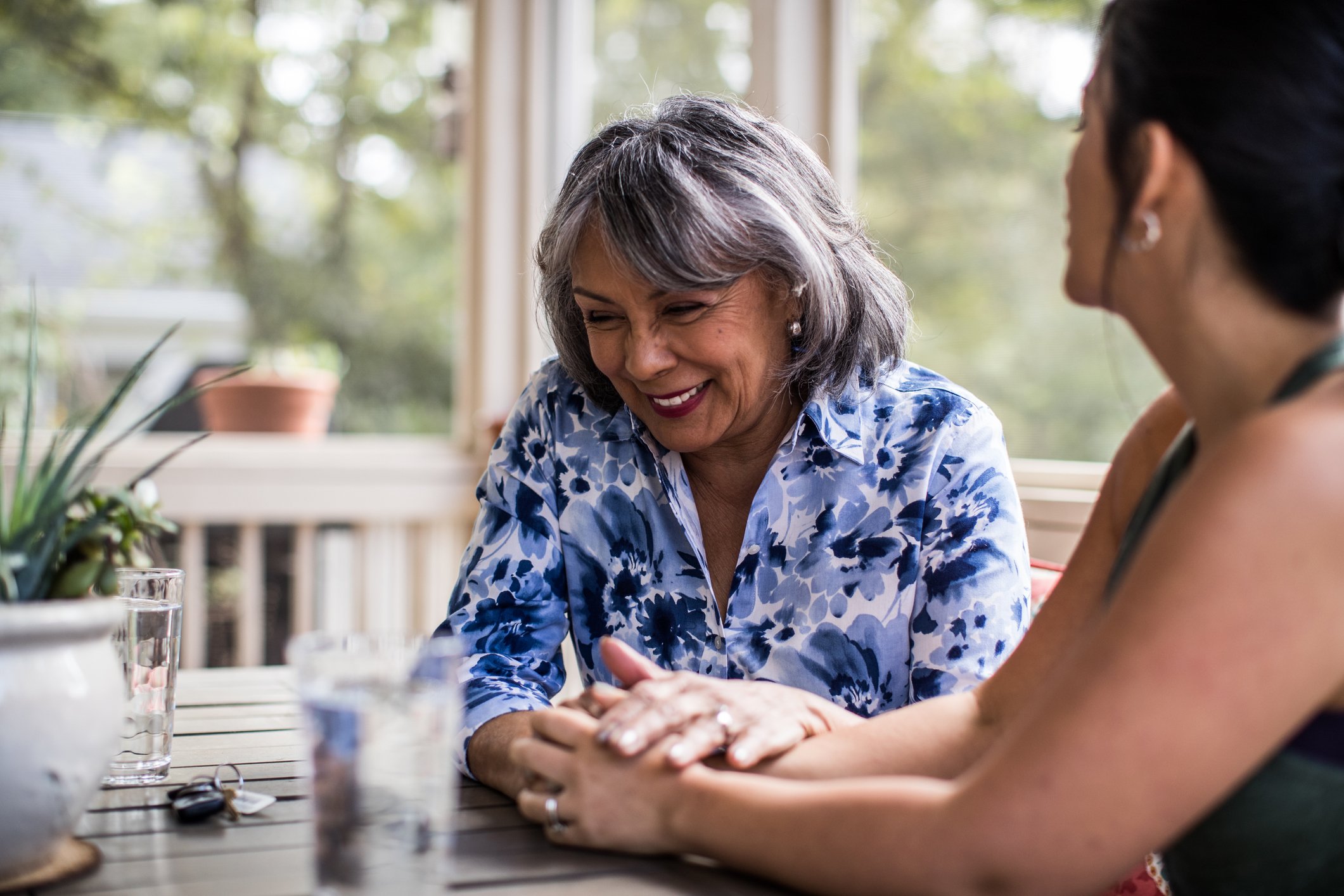 An elderly woman and her adult daughter having a conversation in the living room. | Source: Getty Images