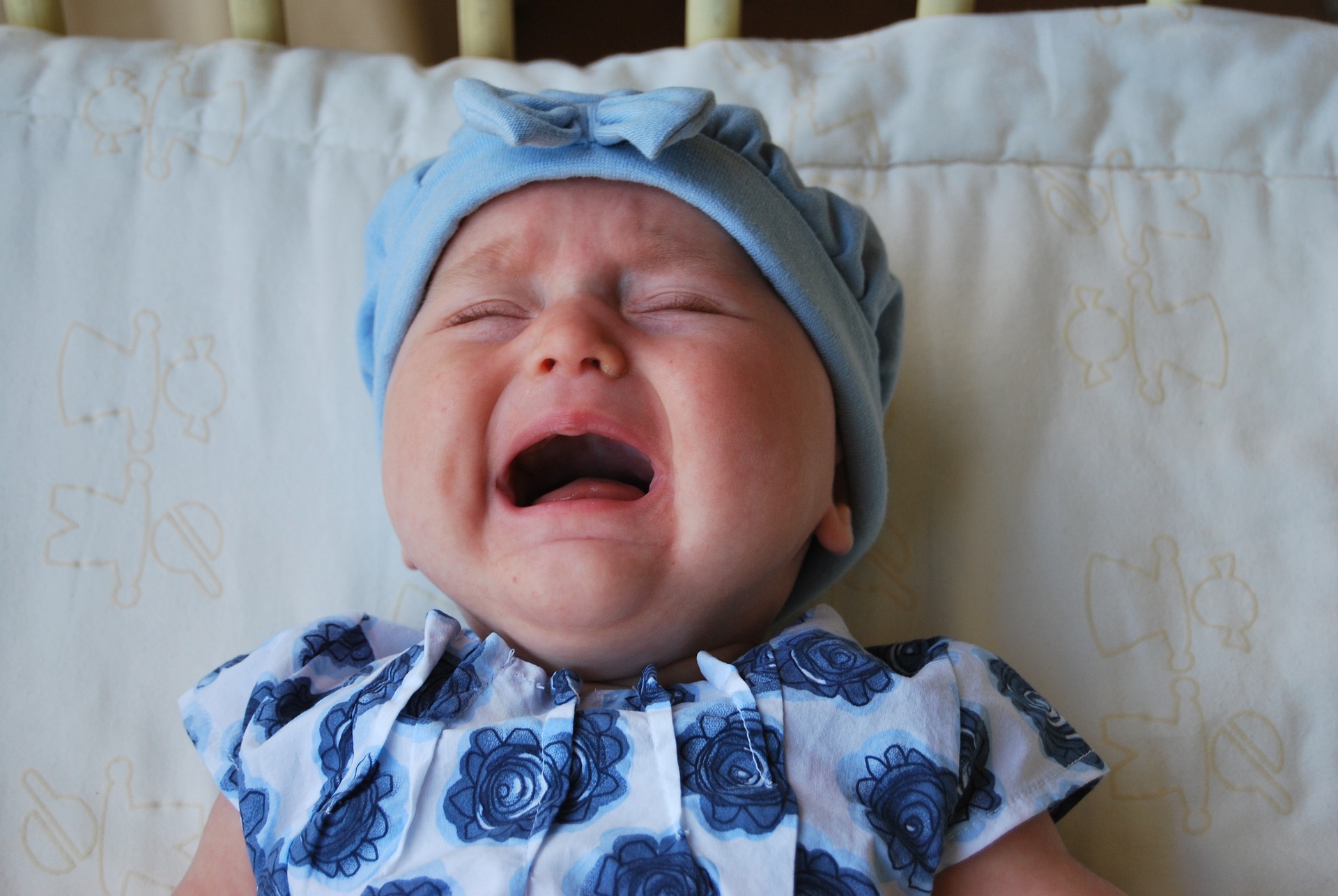 A baby girl crying while lying in a cot | Source: Pixabay