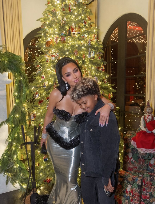 Kim Kardashian and her son Saint West posing in front of a more traditional Christmas tree, from a post dated December 27, 2025 | Source: Instagram/kimkardashian