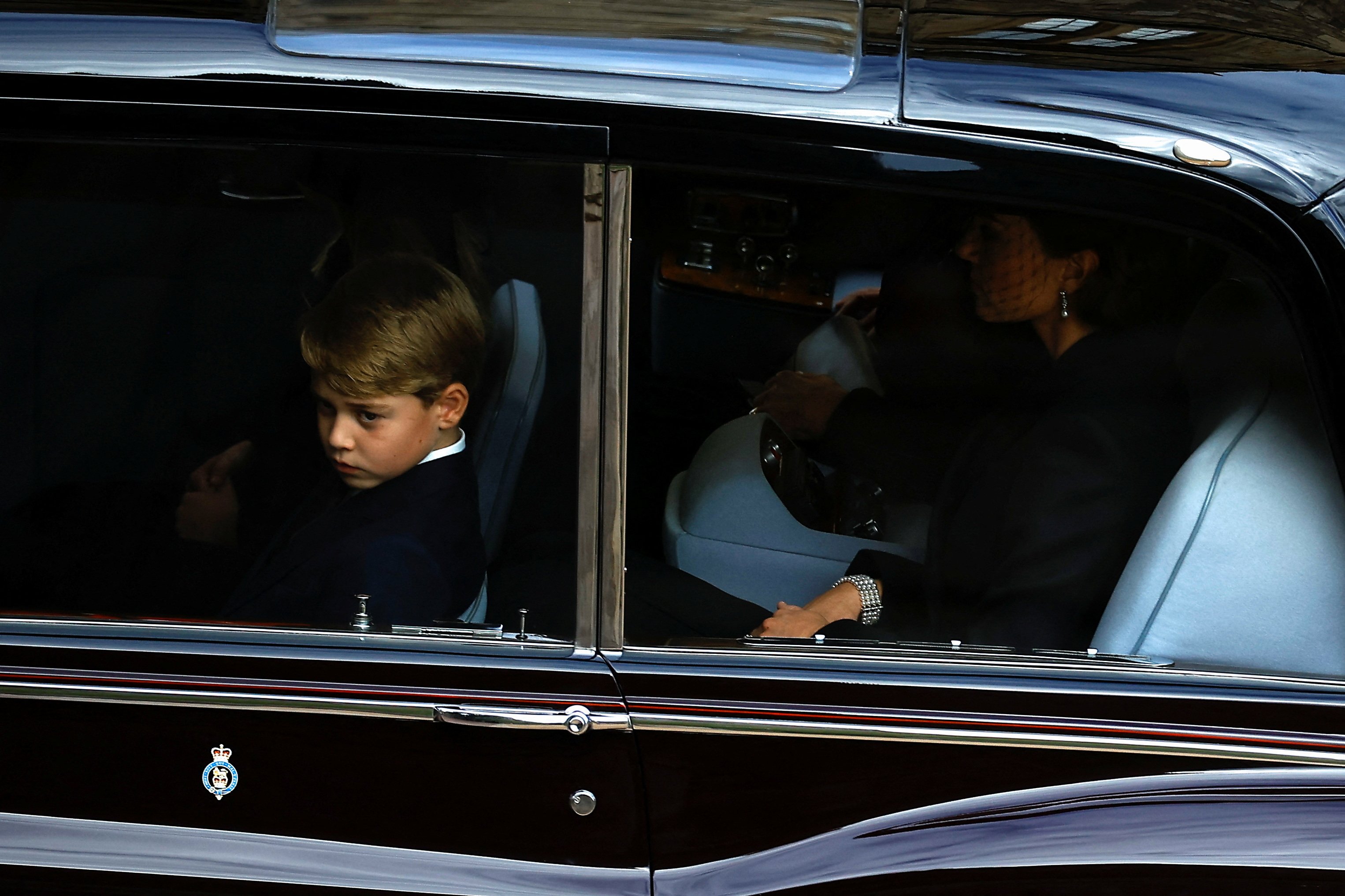 Prince George and Catherine, Princess of Wales sit in a car as it drives on the day of the state funeral and burial of Queen Elizabeth, at Windsor Castle, on September 19, 2022 in Windsor, England. | Source: Getty Images