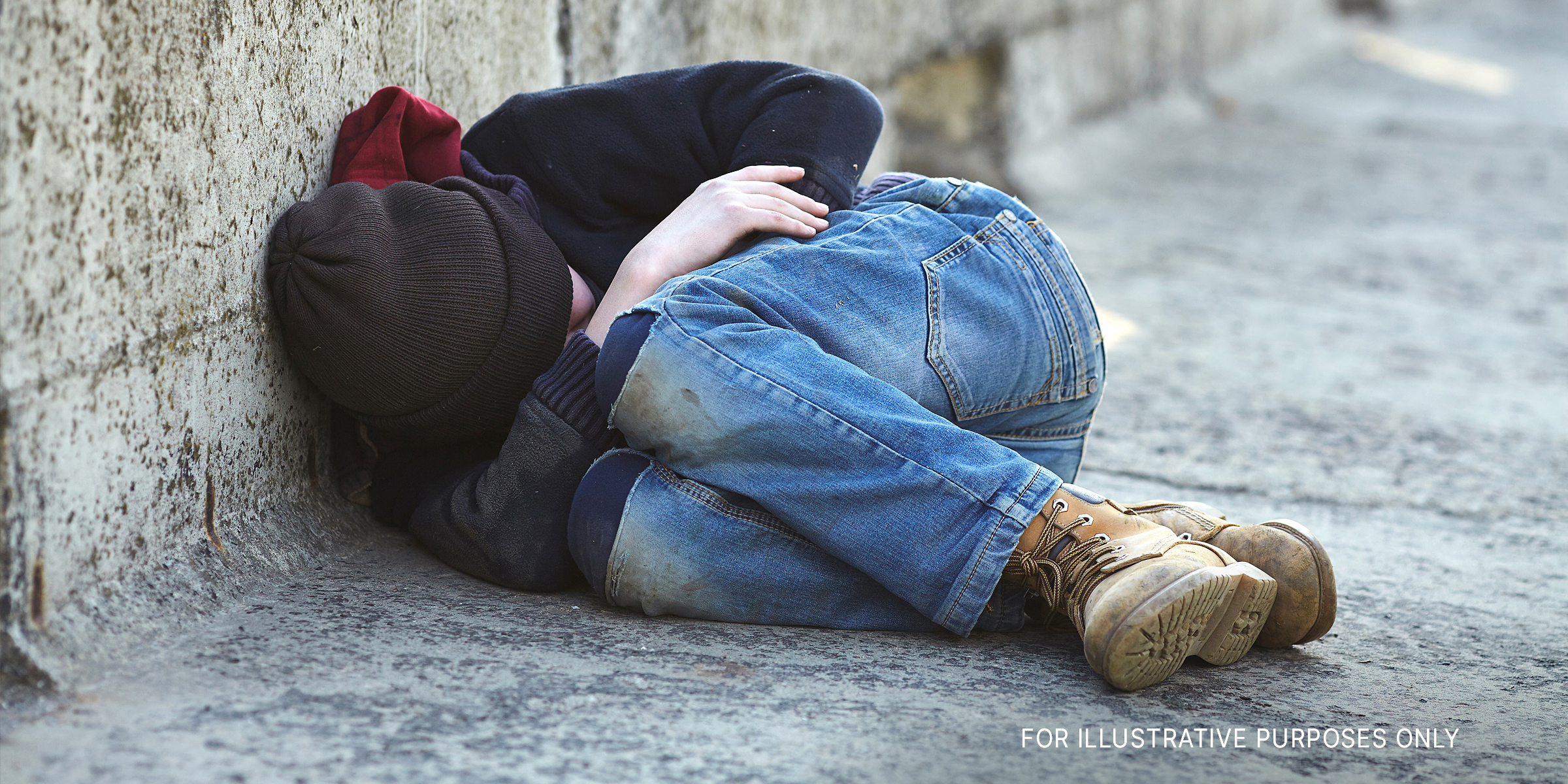 A young homeless boy sleeping on a bridge | Source: Shutterstock