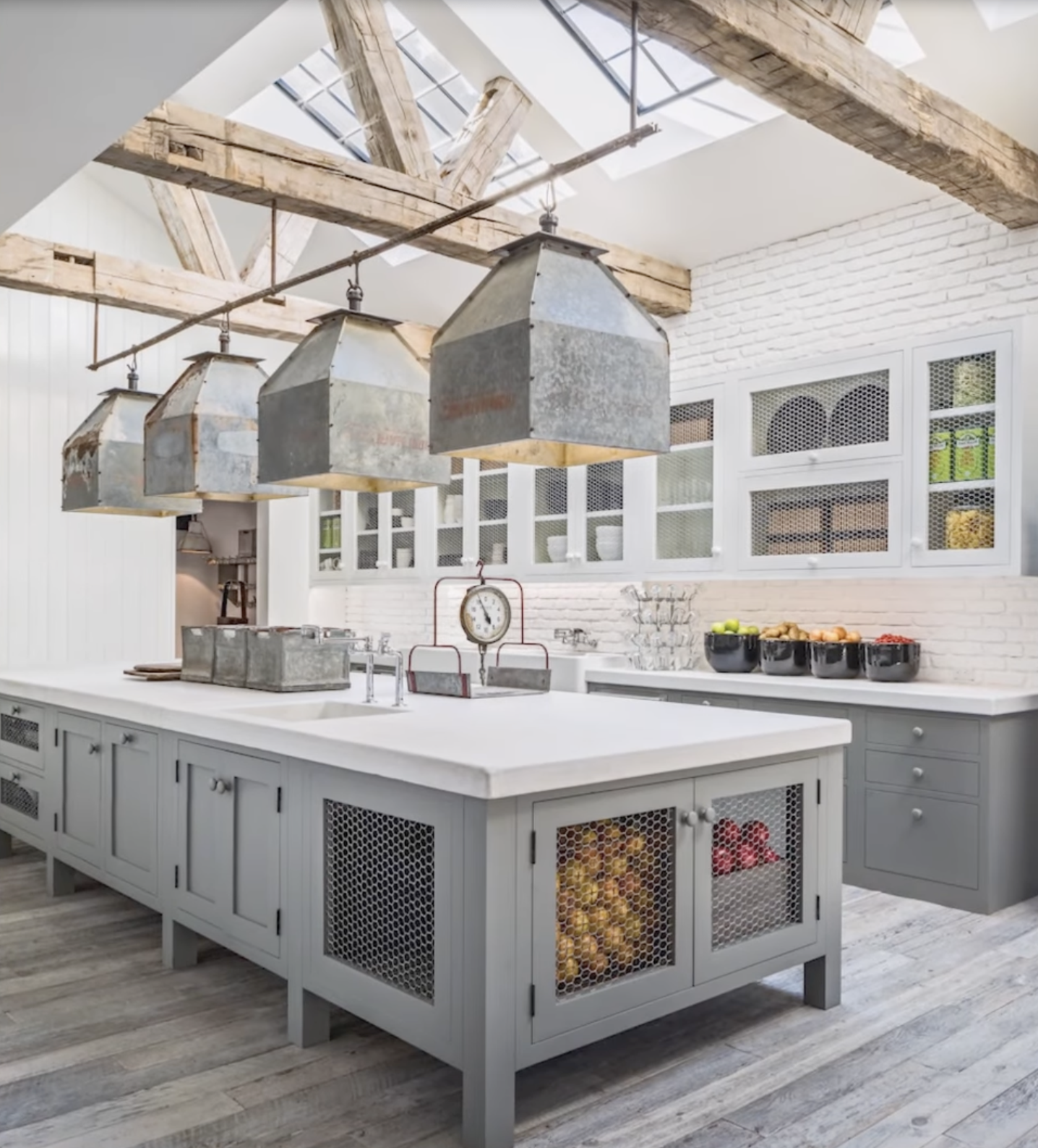 Kitchen island with vintage scale, industrial lighting, and exposed beams inside Diane Keaton’s Sullivan Canyon home, dated February 3, 2022 | Source: YouTube/@FamousEntertainment500k