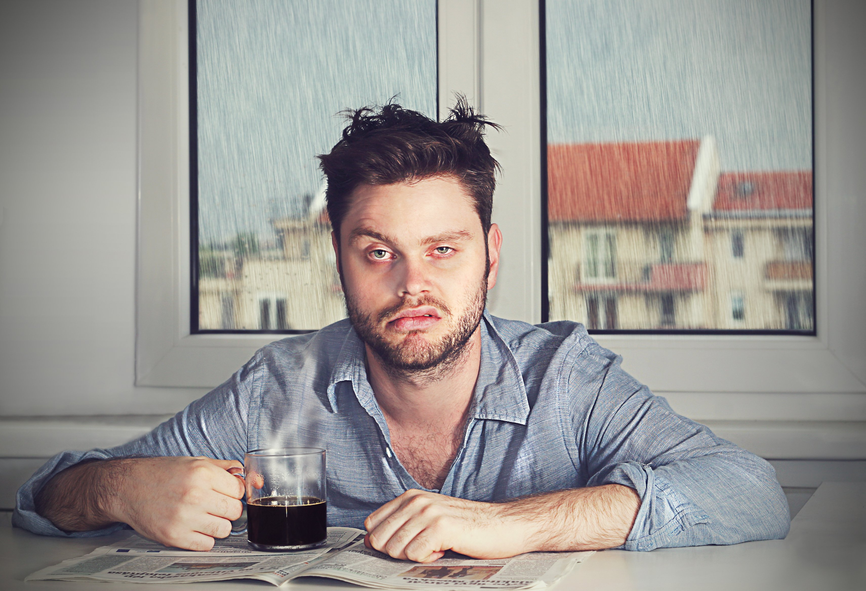 Man looking disheveled while drinking coffee | Photo: Shutterstock/Akos Nagy