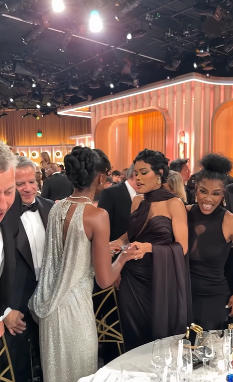 Teyana Taylor converses with another woman in silver outfit as her mother, Nikki Taylor is behind her smiling, from a post dated January 12, 2026. | Source: Instagram/enews