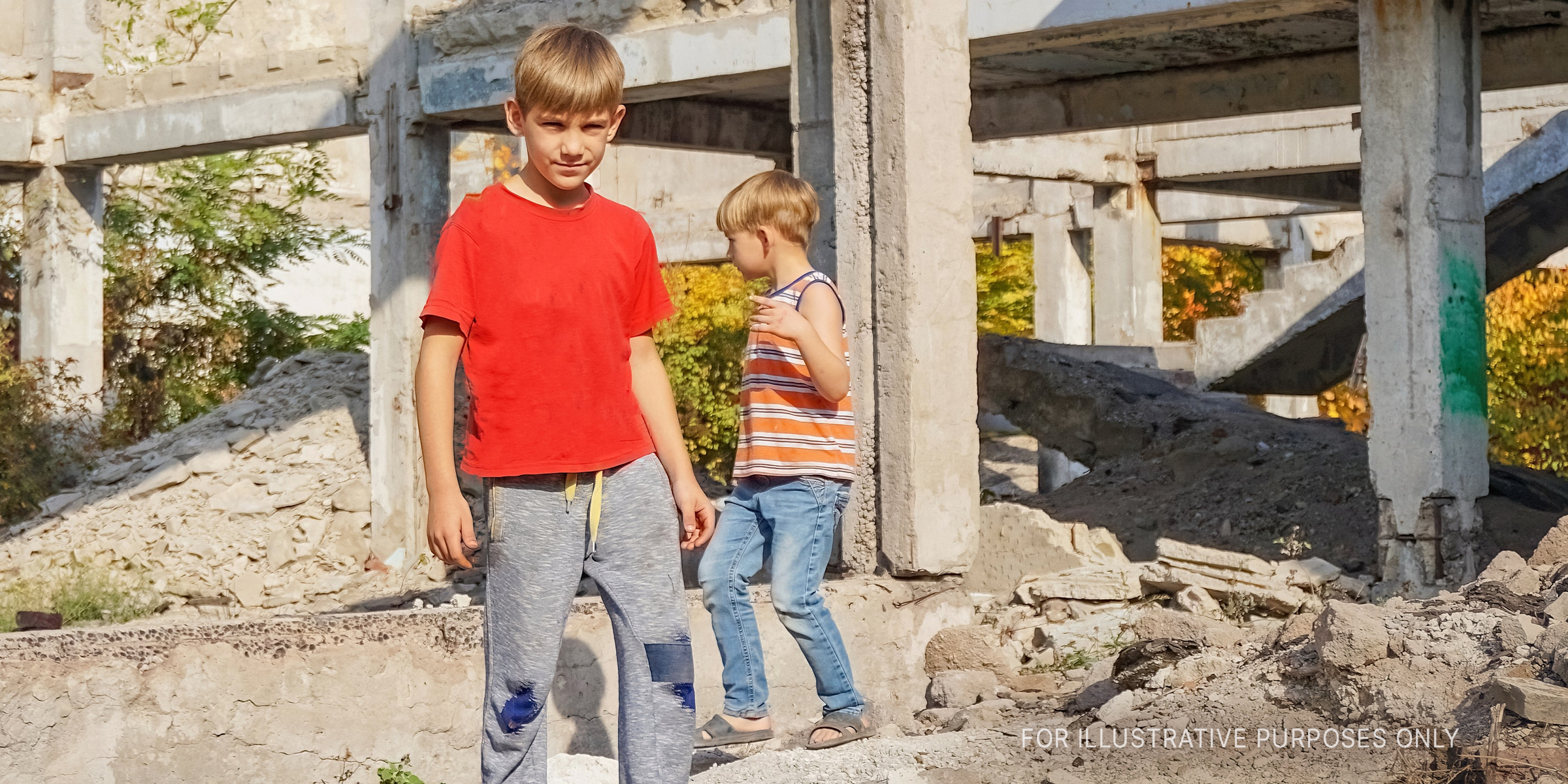 Two young boys standing near old concrete pillars | Source: Shutterstock