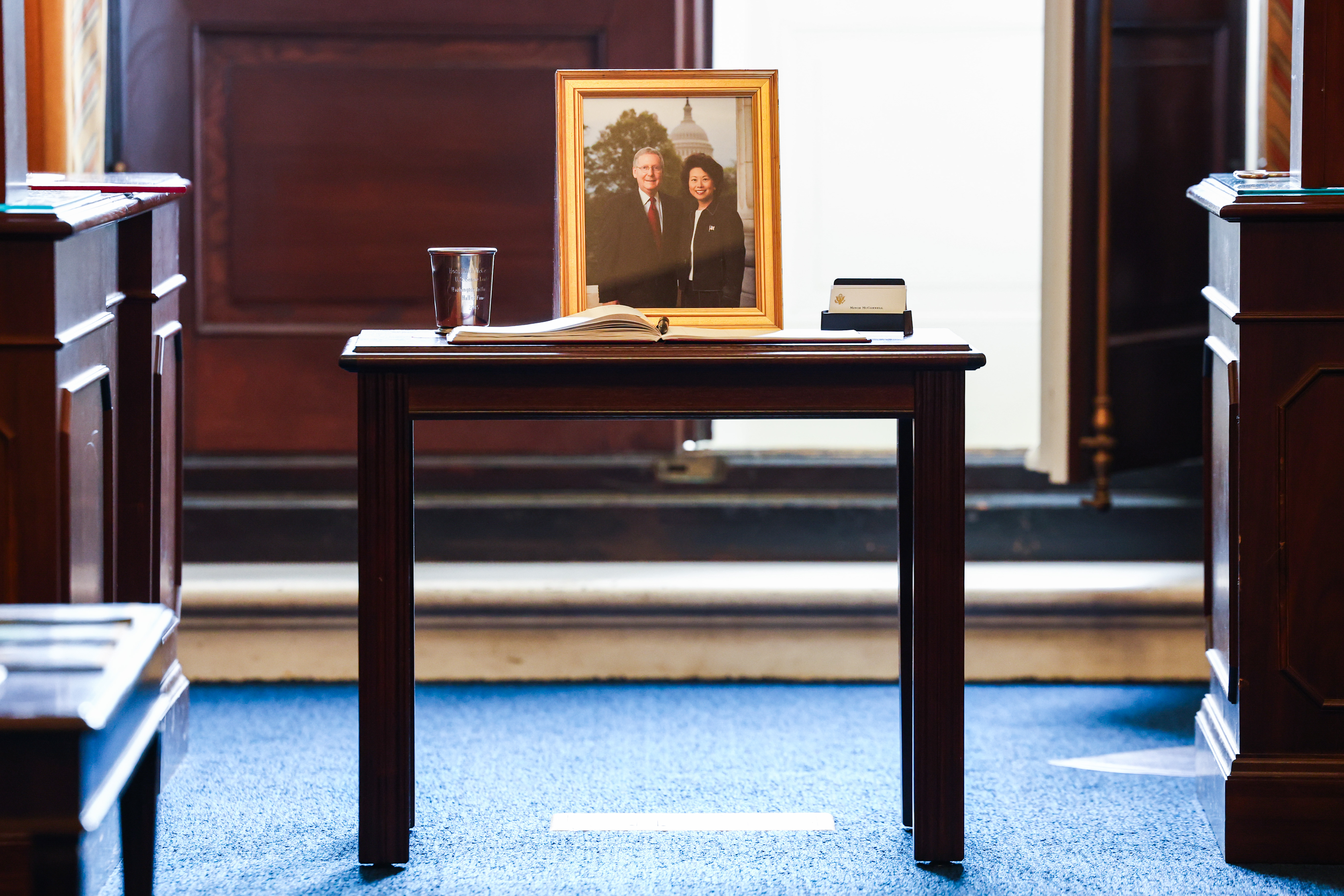 A framed photo of Mitch McConnell and his wife, Elaine Chao, sits inside the senator's office at the Russell Senate Office Building. Weeks later, McConnell publicly explained that his recent hospitalization was caused by a fall and shared new details about his recovery. | Source: Getty Images