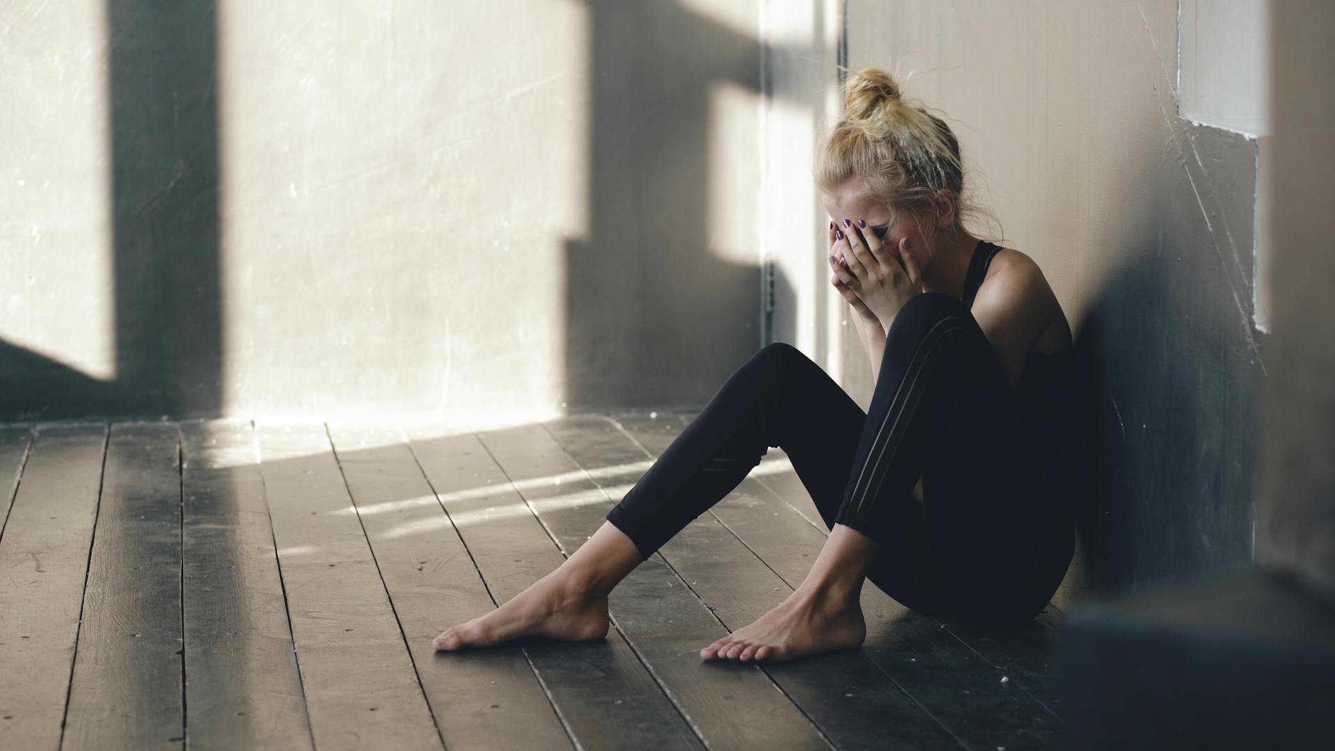 A woman sitting on the floor, crying | Source: Pexels