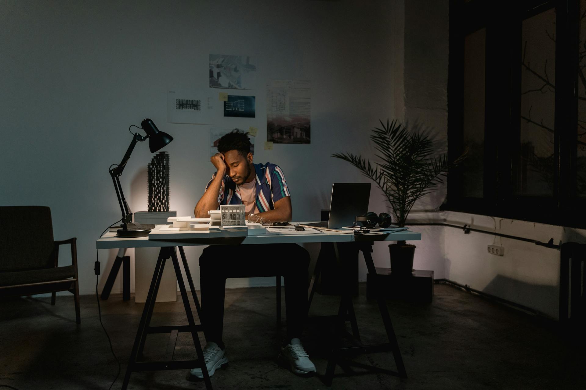 A man sitting behind his work table feeling exhausted | Source: Pexels