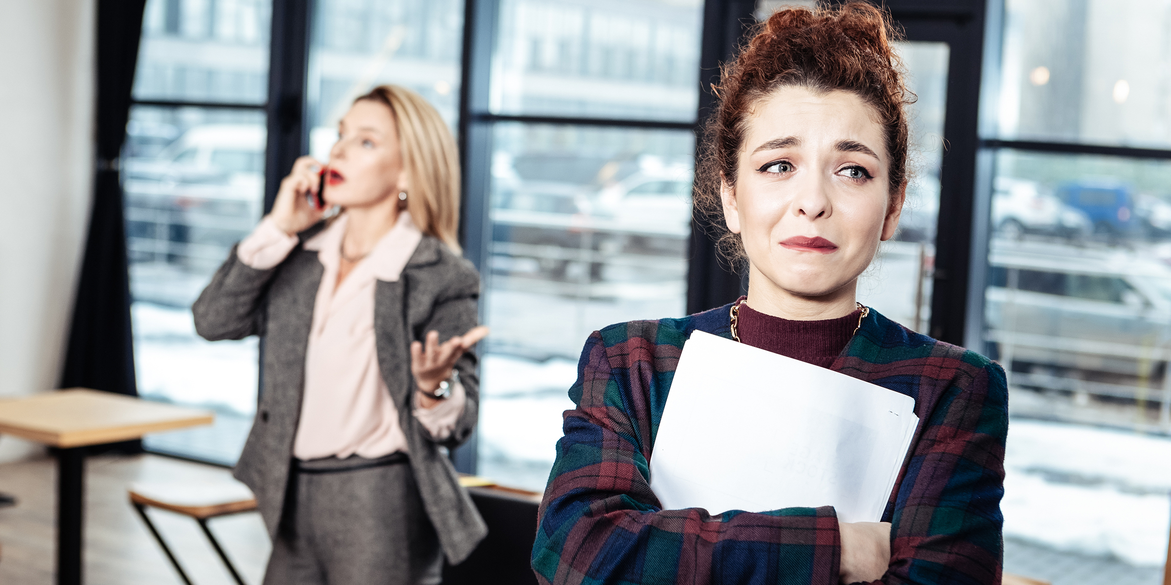 Anxious woman in front of boss | Source: Shutterstock